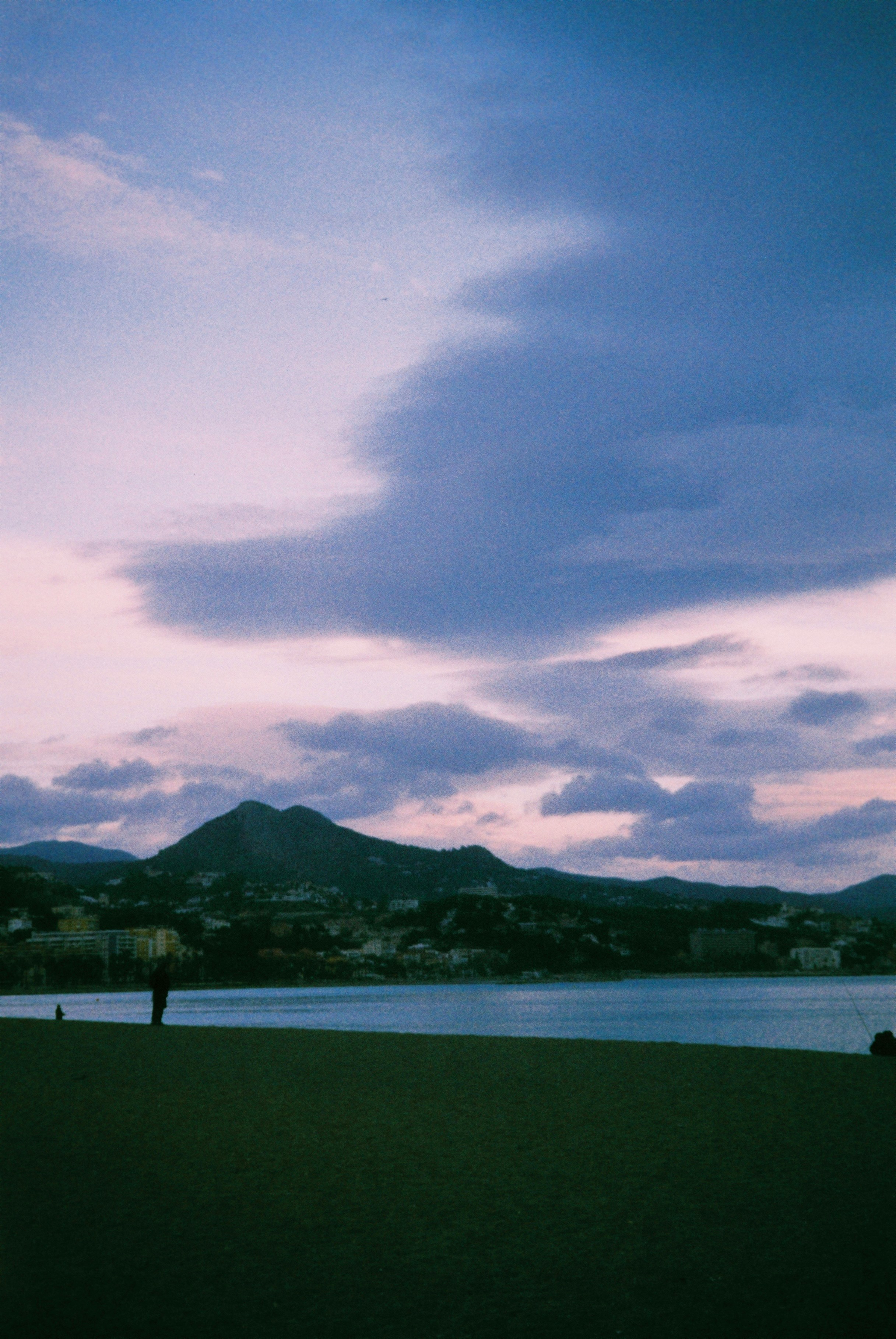 Distant mountain range under a cloudy, pastel sky.