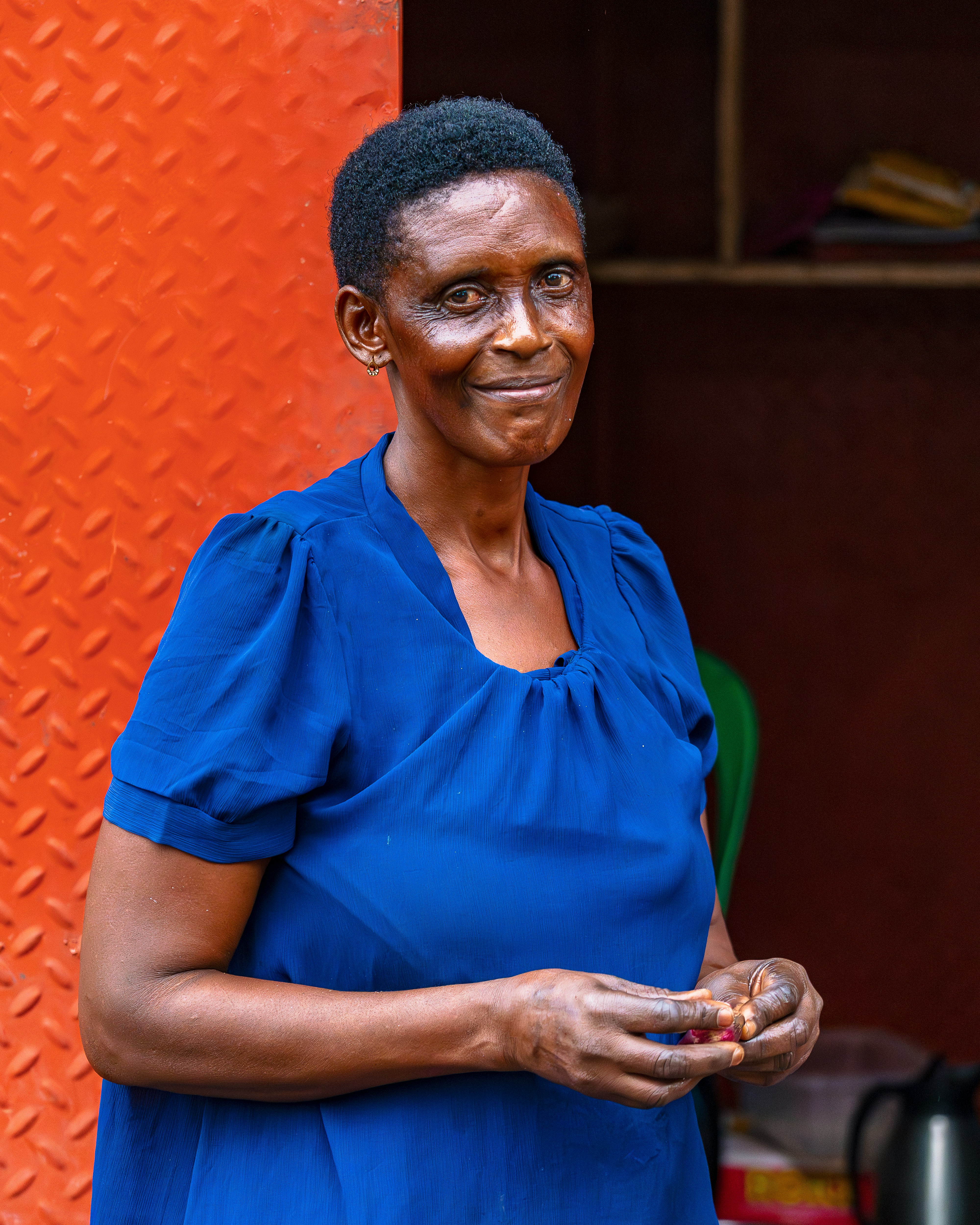 A woman in a blue dress smiles warmly.