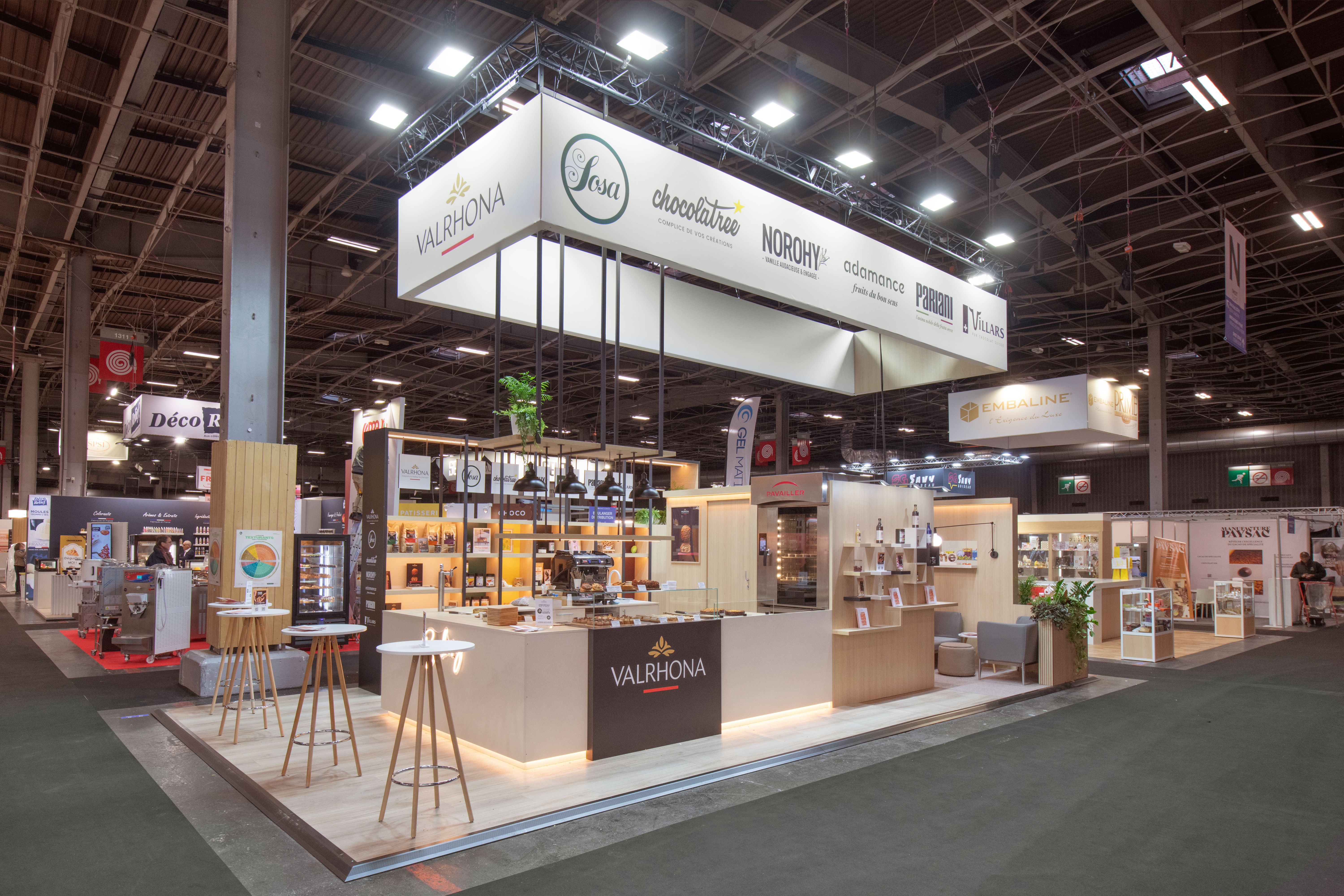 Stand Valrhona Bake and Snack 2026 par Expace – vue d'ensemble avec espace dégustation et présentation gammes chocolat professionnel, mobilier épuré et signalétique premium