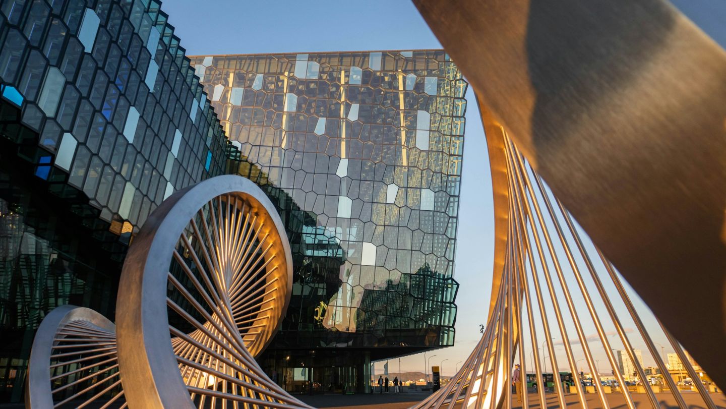 Exterior of Harpa Concert Hall in Reykjavík with its iconic glass facade at golden hour.