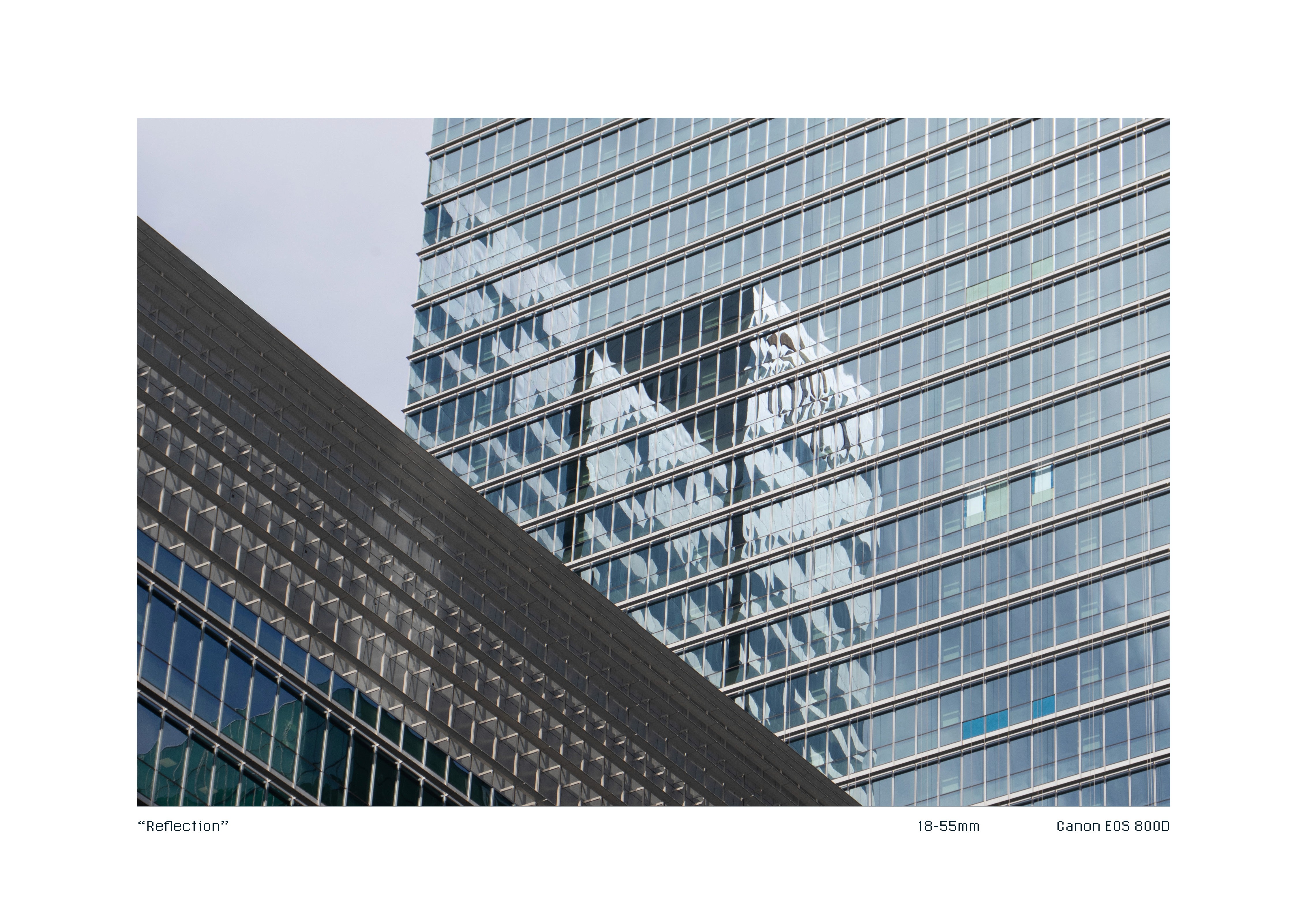 Mirrored reflection of another building on the glass panes of a building