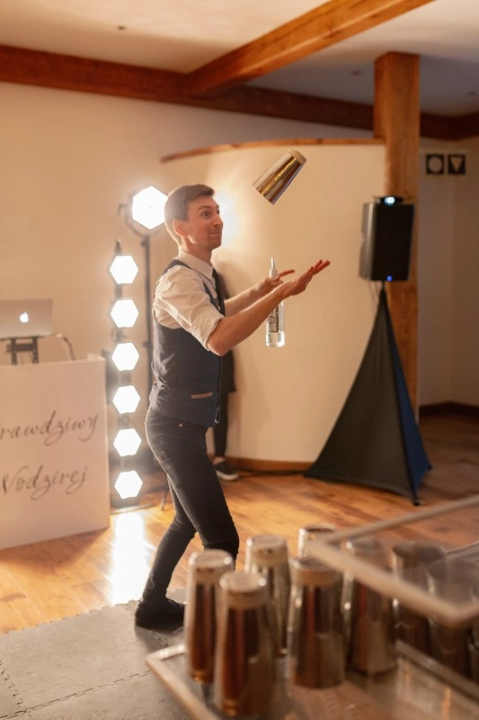 elegancki koktajl przygotowywany przez barmana na wesele przy pomocy sitka