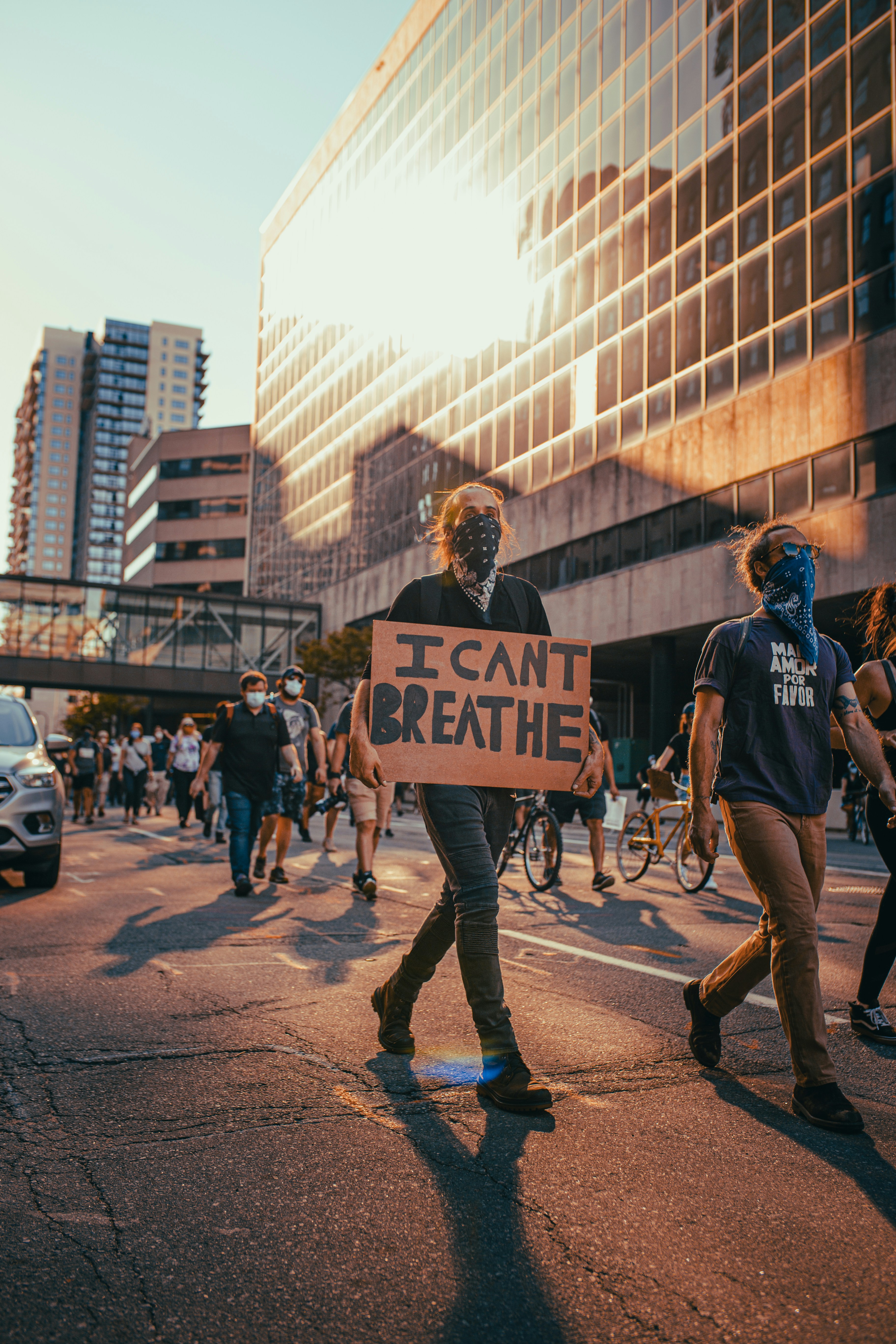 Protesters on a city street, one holding a sign with "I can't breathe"