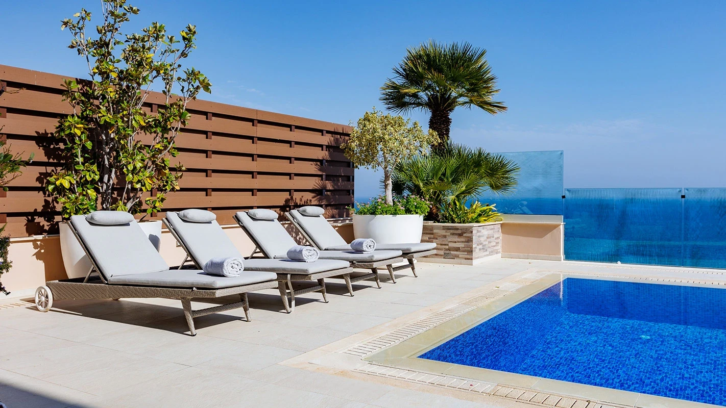Seafront Residence Limassol sun deck with poolside loungers, privacy screen, and coastal-blue waterline