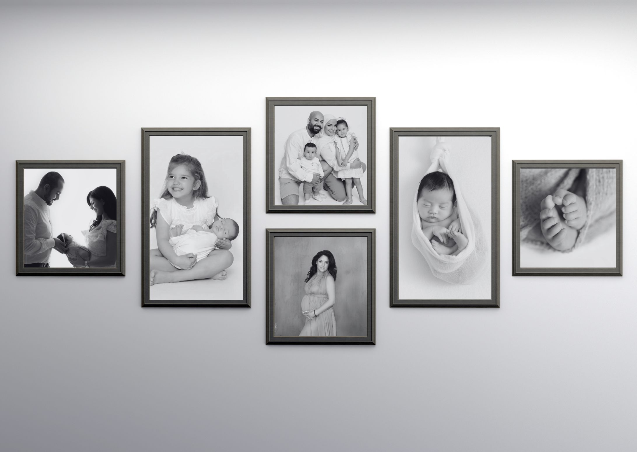 Black and white family photo wall gallery with framed portraits