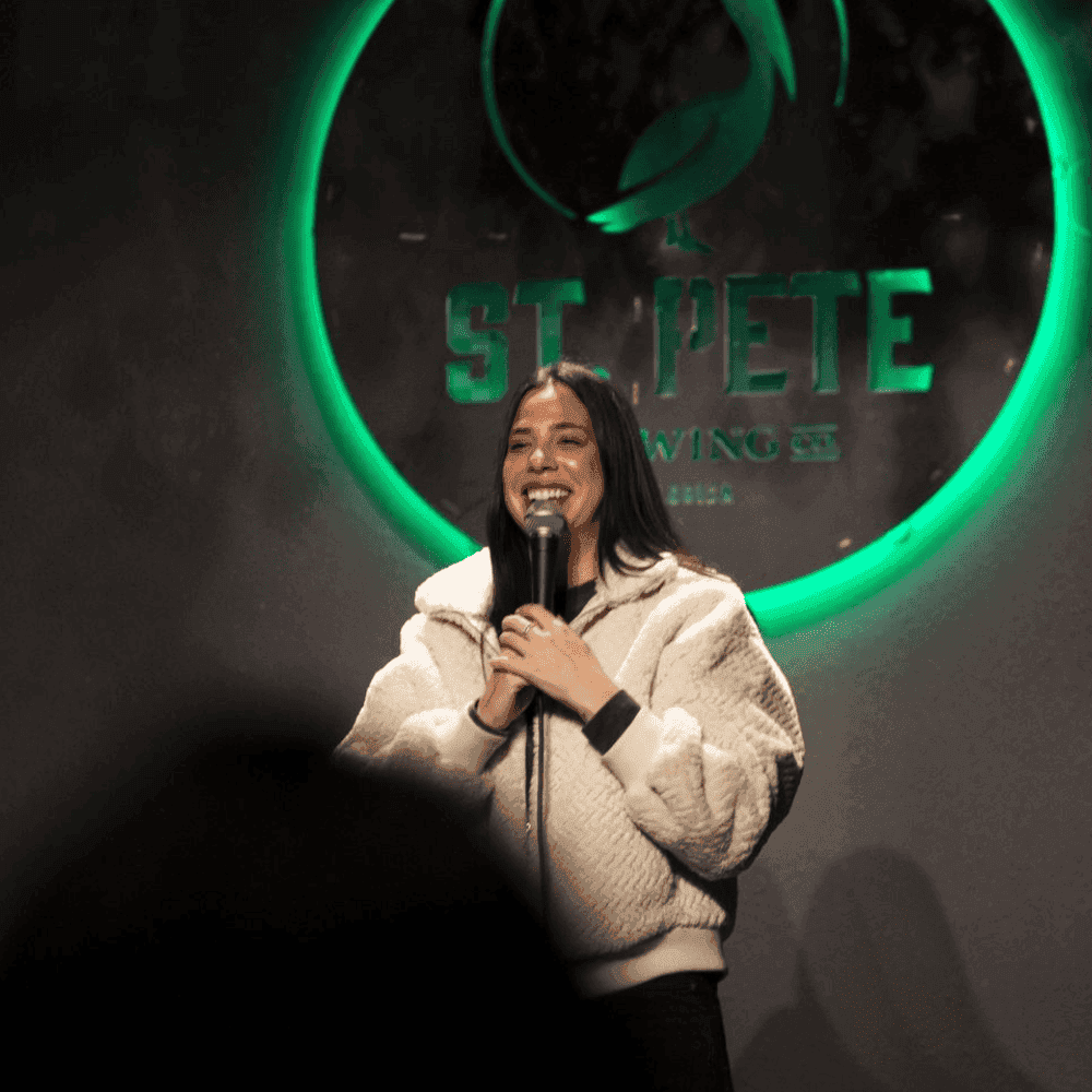 A hilarious female comedian on stage St Pete Standup show
