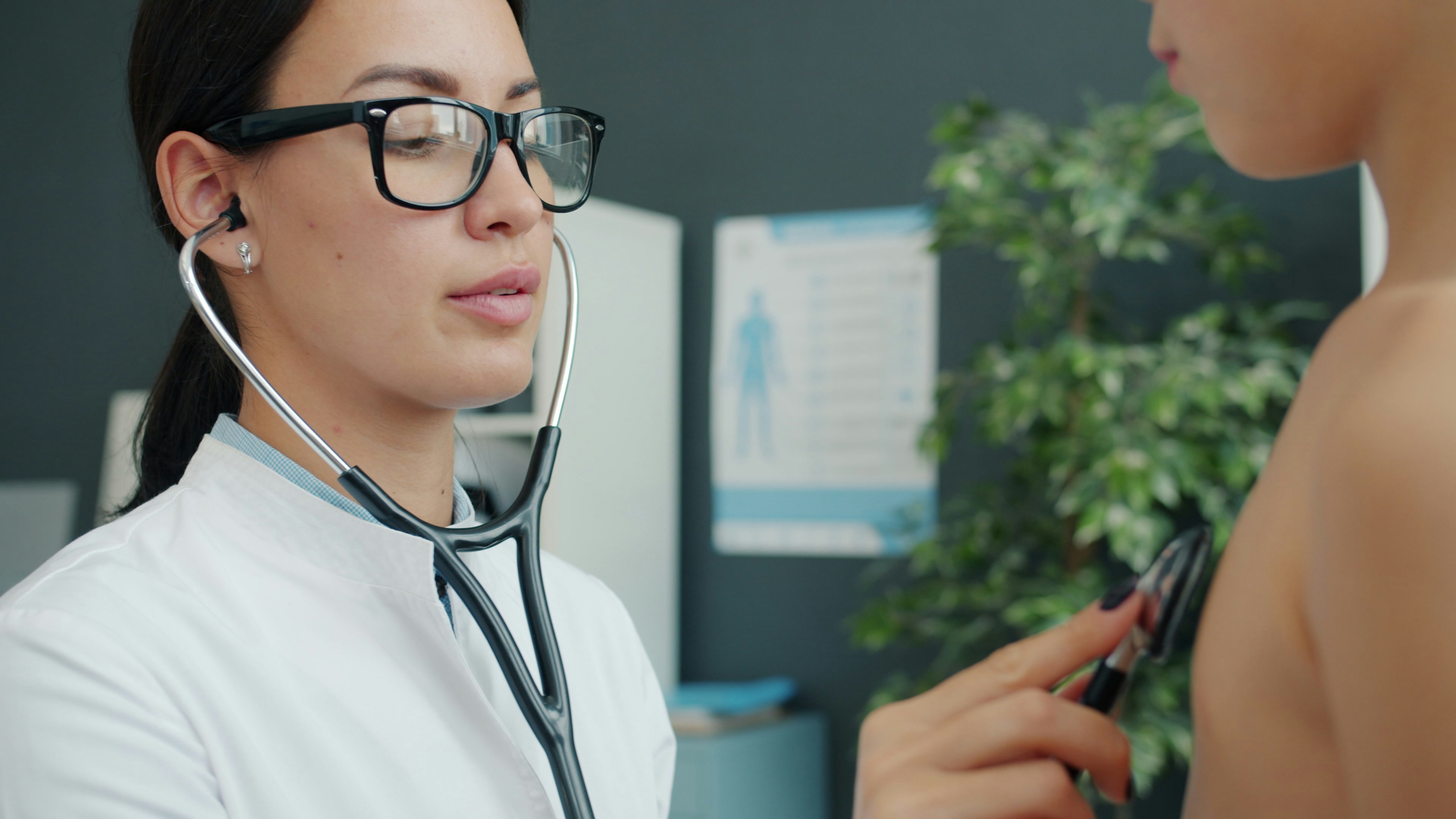 Doctor examines child with stethoscope in clinic.