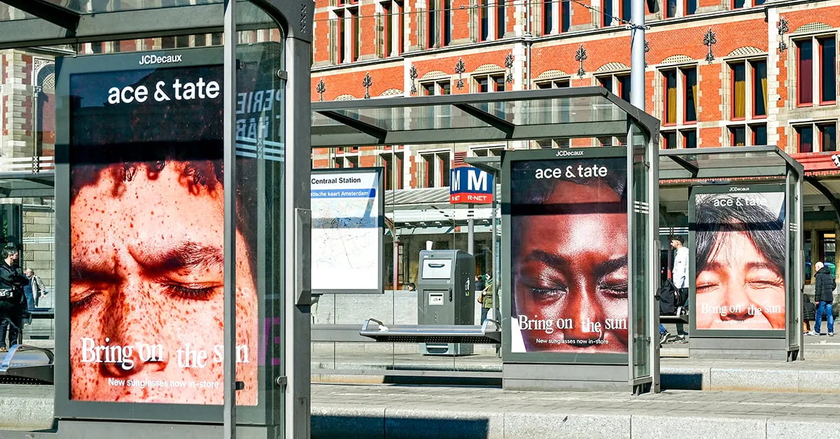 a man walking down a street past a large poster