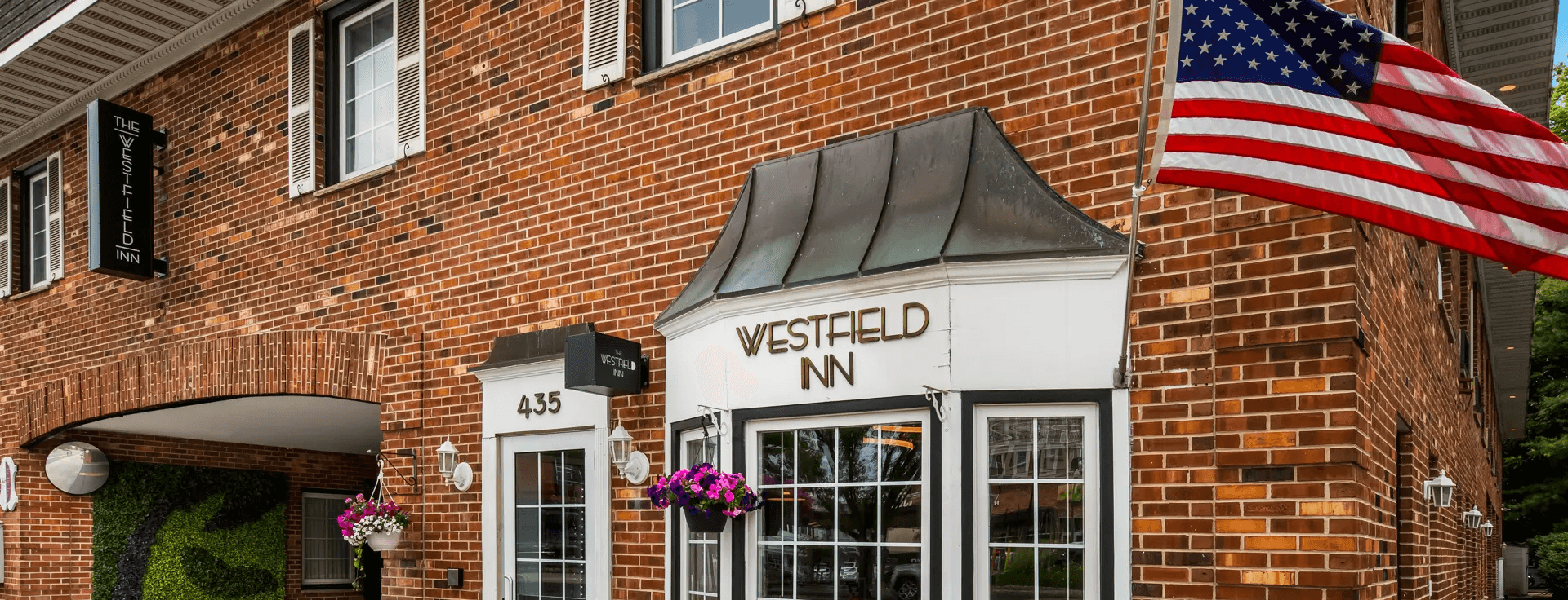 Black and white photo of a brick building with a sign reading Westfield Inn.
