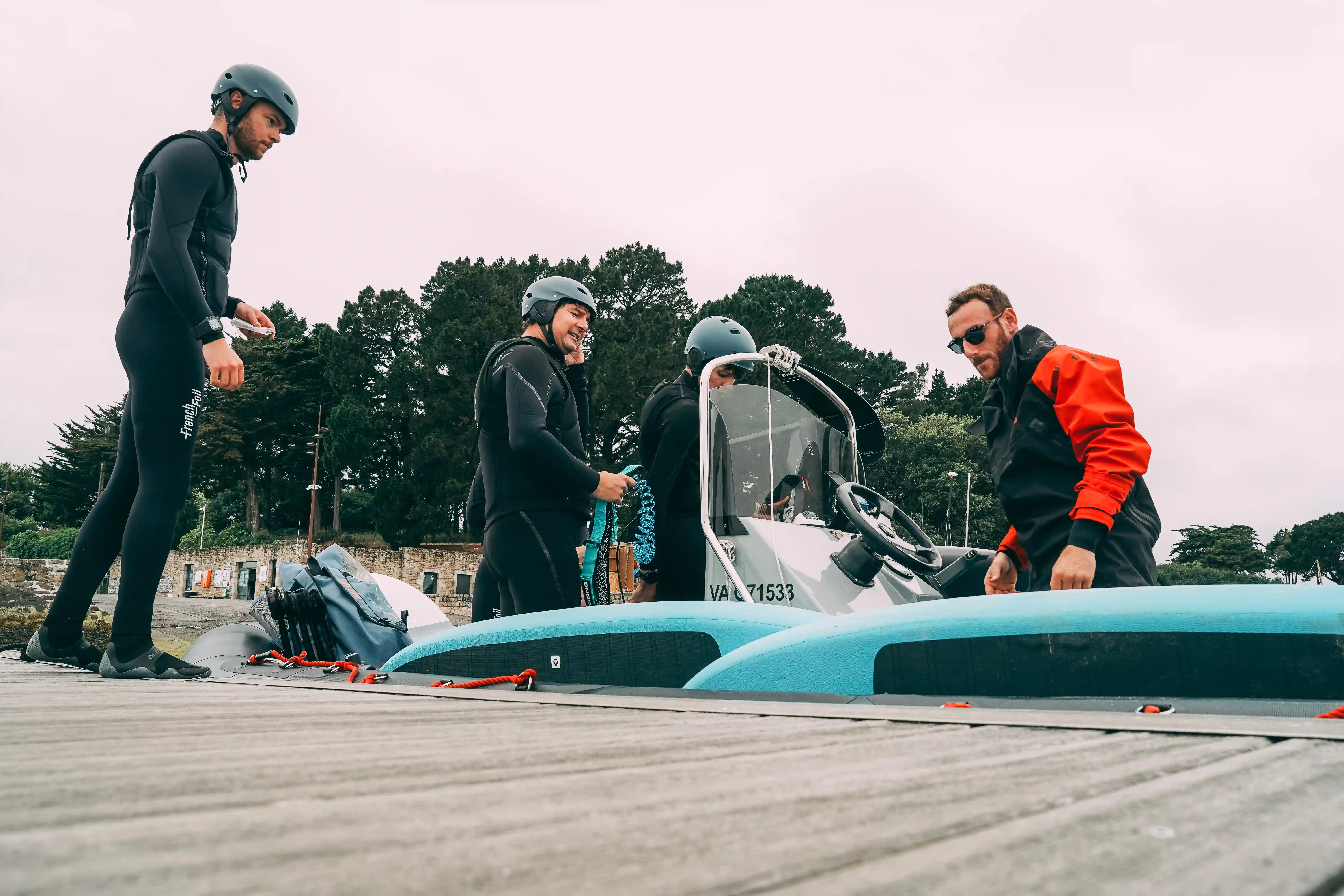 Un moniteur et ses élèves sur un bateau lors d'un cours de wingfoil