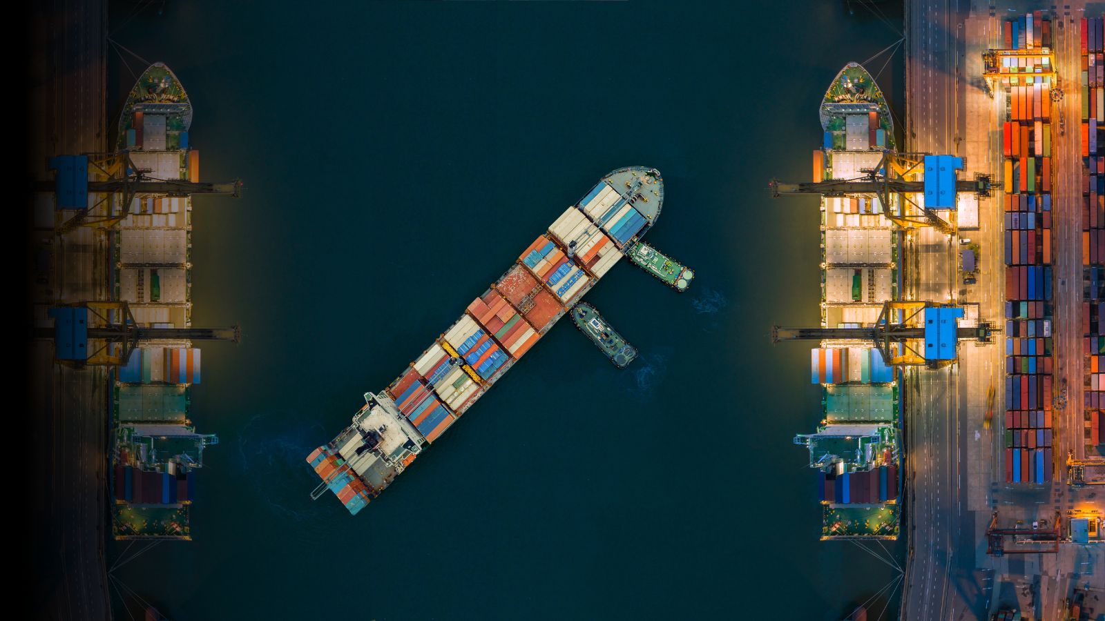 Aerial view of a cargo ship and containers at a busy port terminal