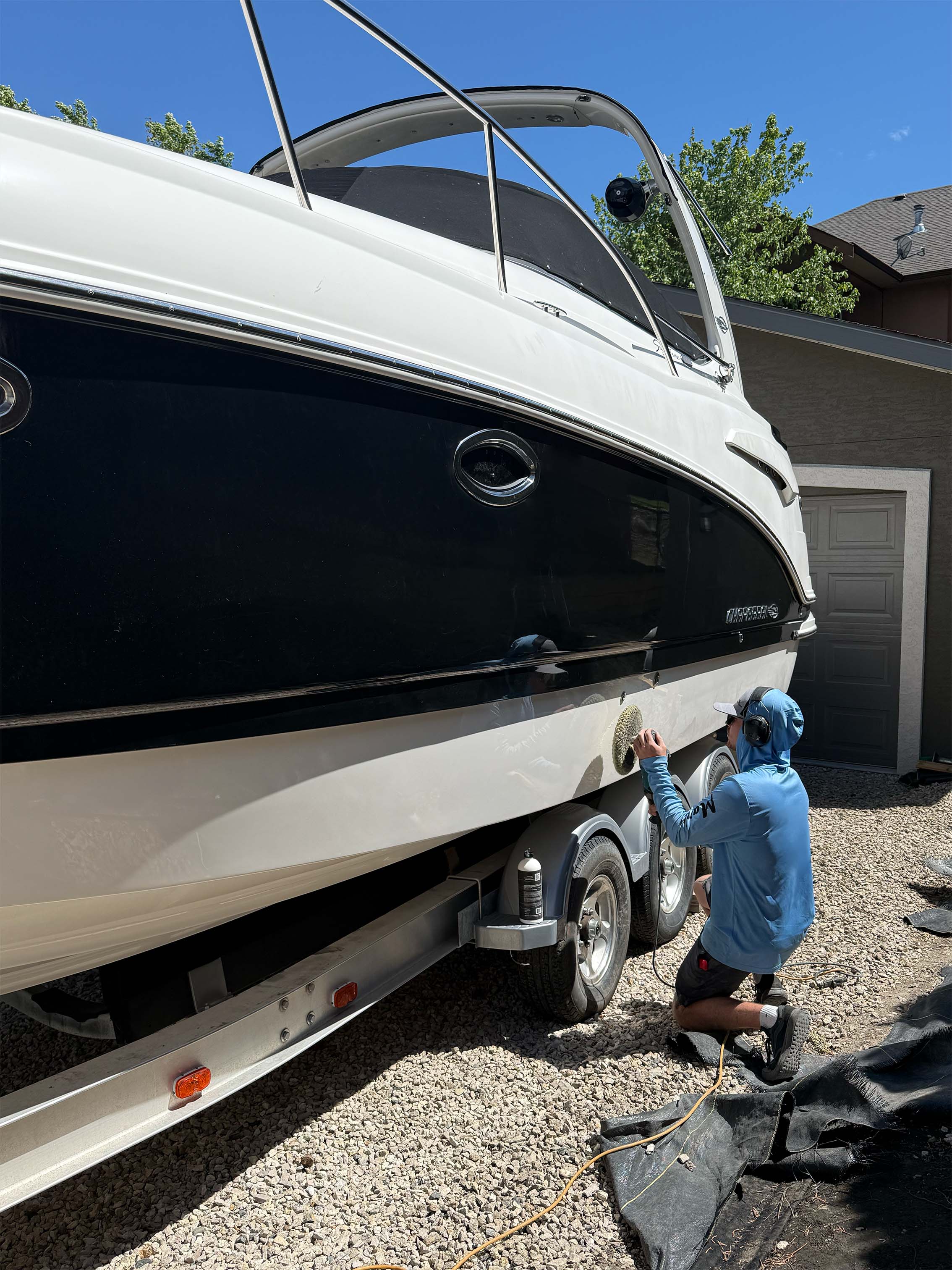 A man polishing and detailing the hull of a boat