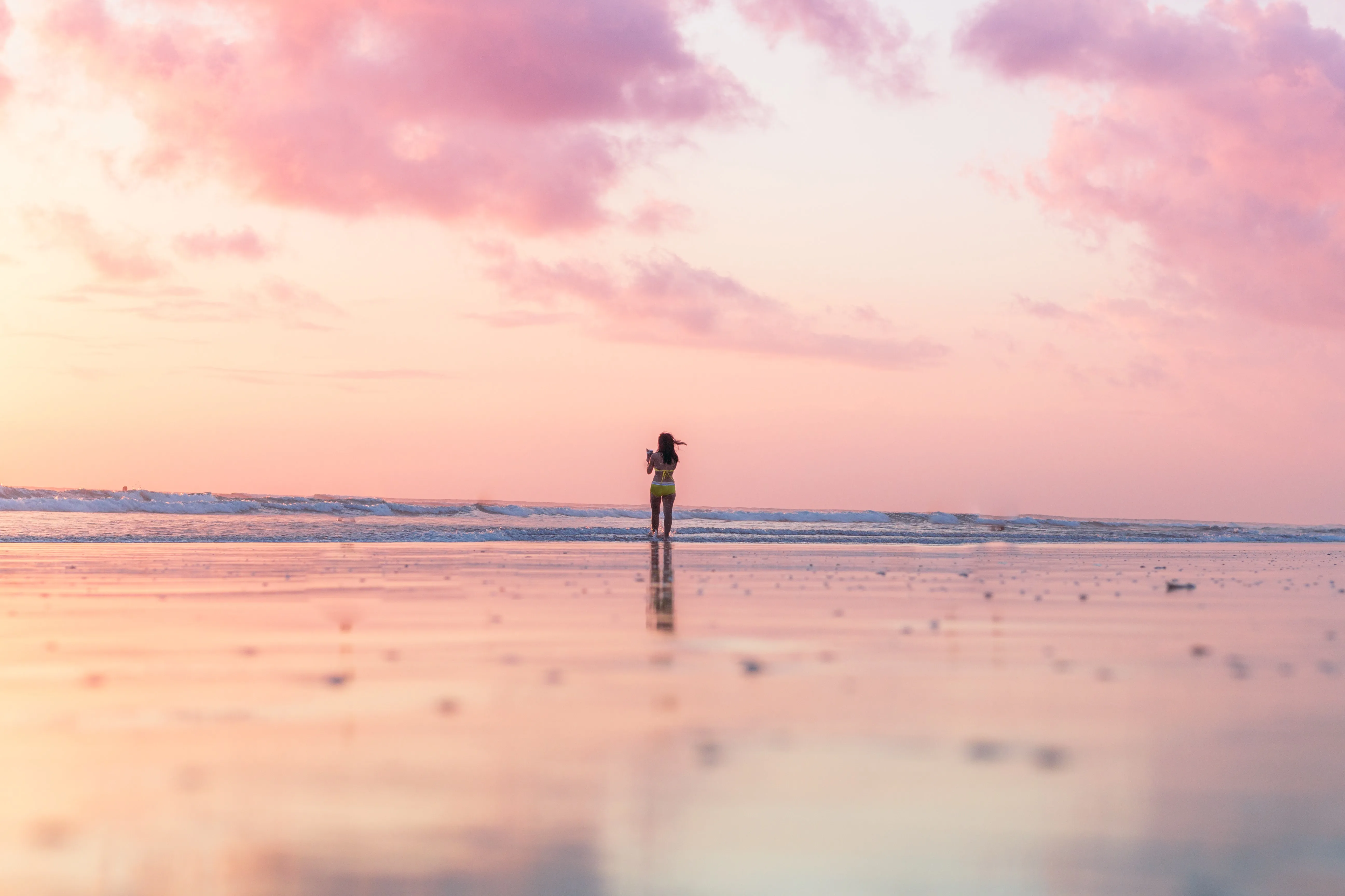 Woman admiring beautiful sunset over Bali beach