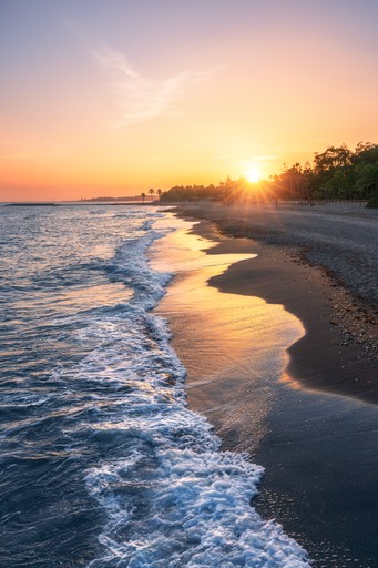 An orange arch rock formation with sunlight peeking through