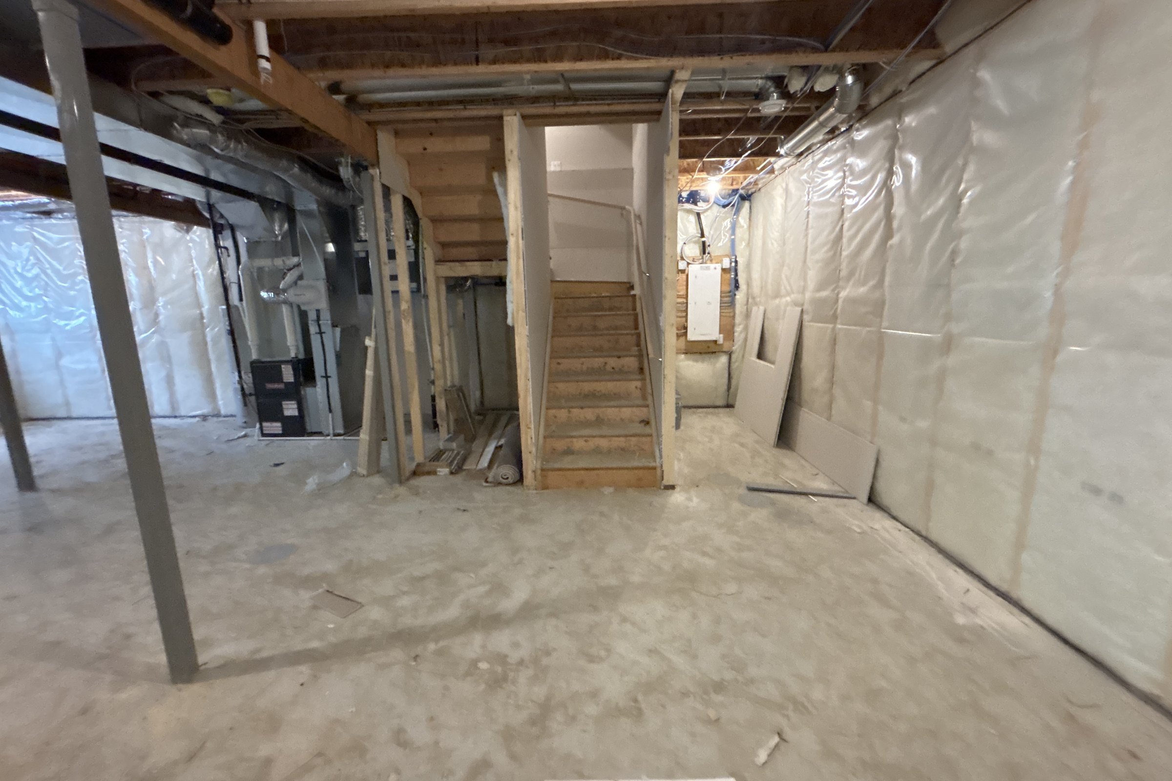 Unfinished basement before: open stair and framing