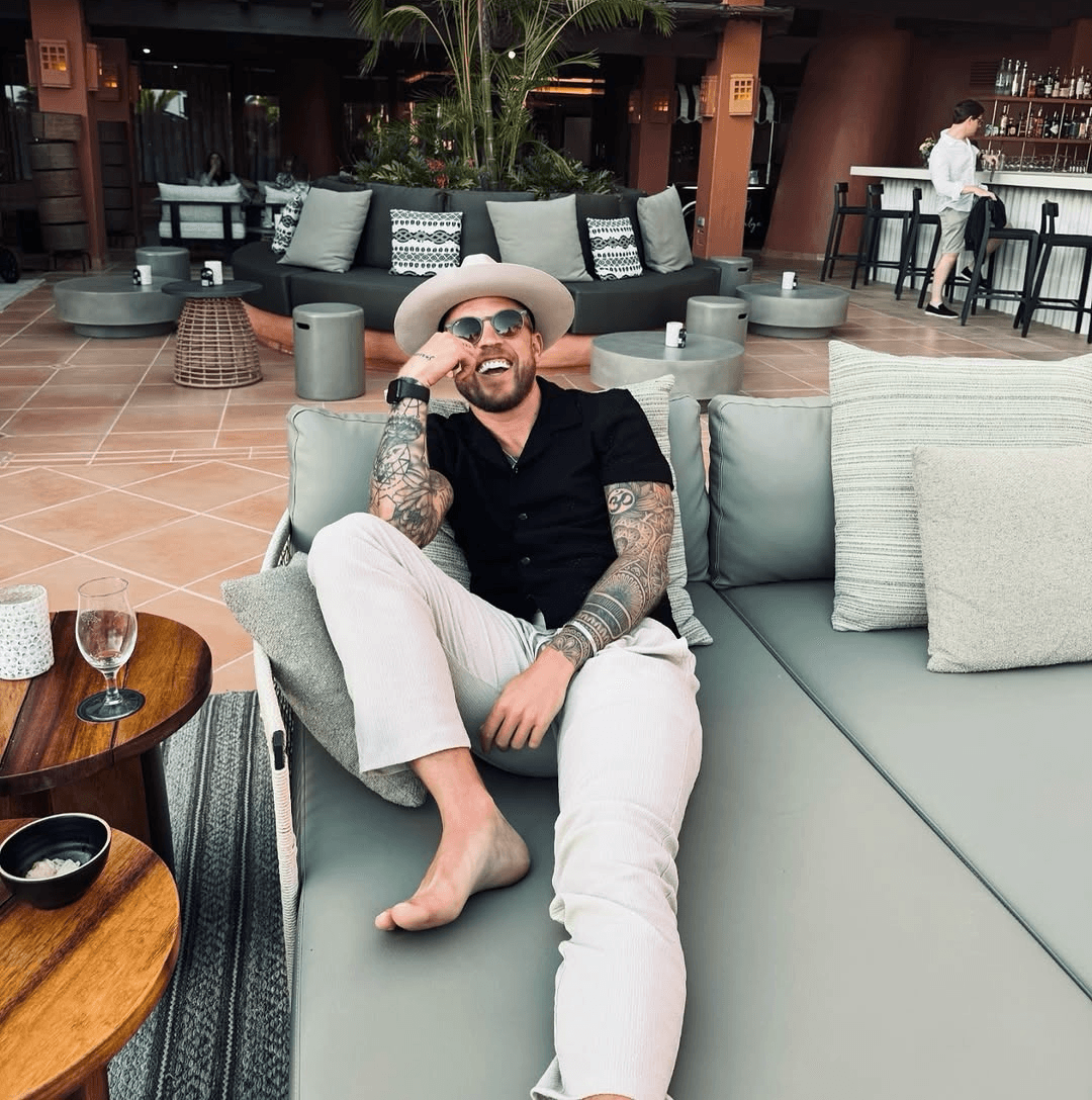 A man stading with Surfboard