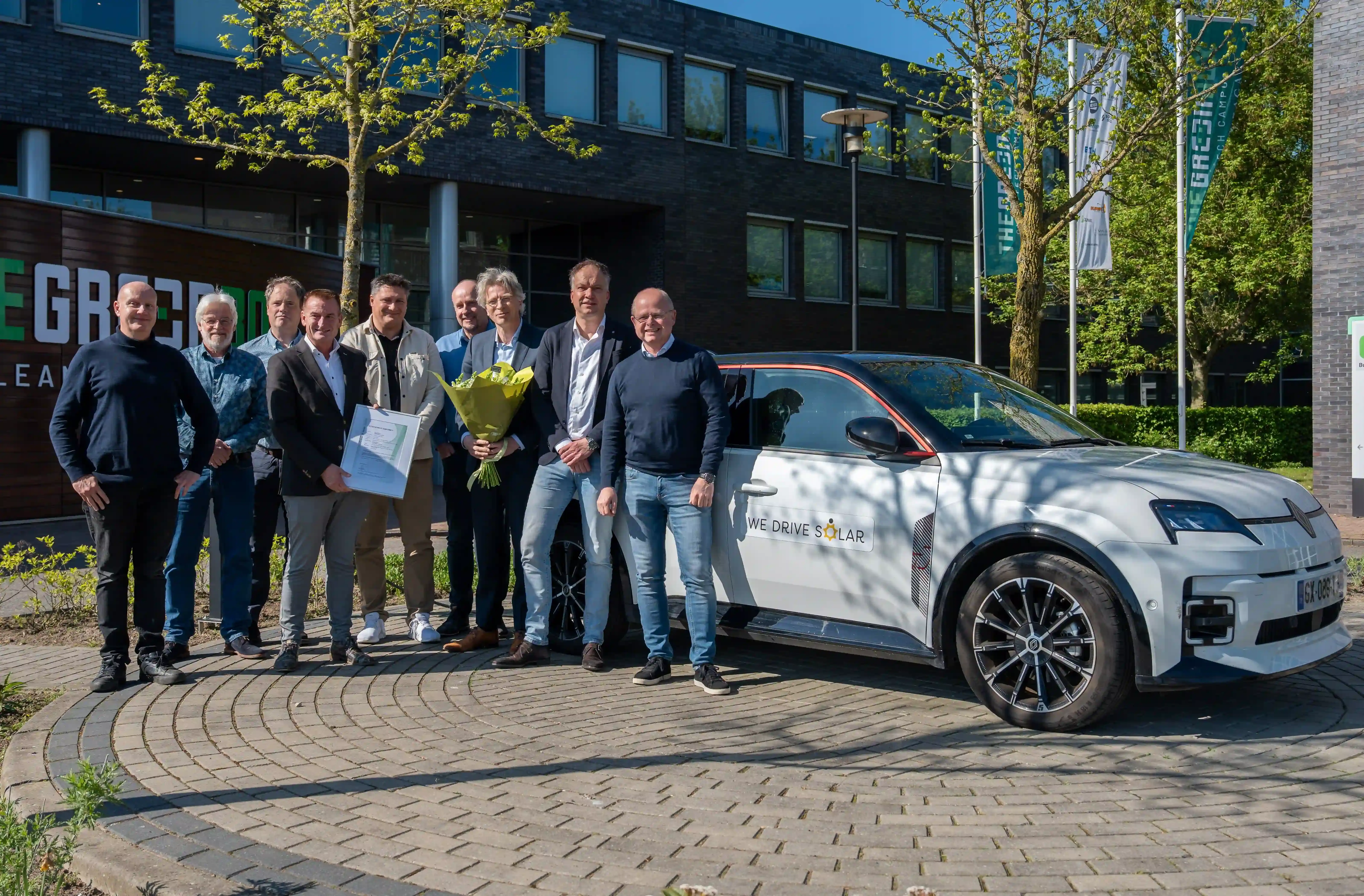 Groepsfoto van Bram Holtus met We Drive Solar medewerkers met de conformiteitsverklaring op het hoofdkantoor van We Drive Solar in Hengelo