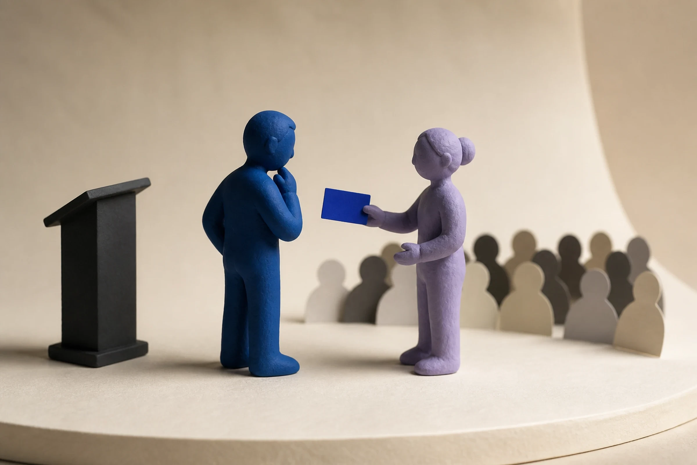 A blue clay speaker considers a blank cue card offered by a lavender coach beside a lectern and a paper audience.