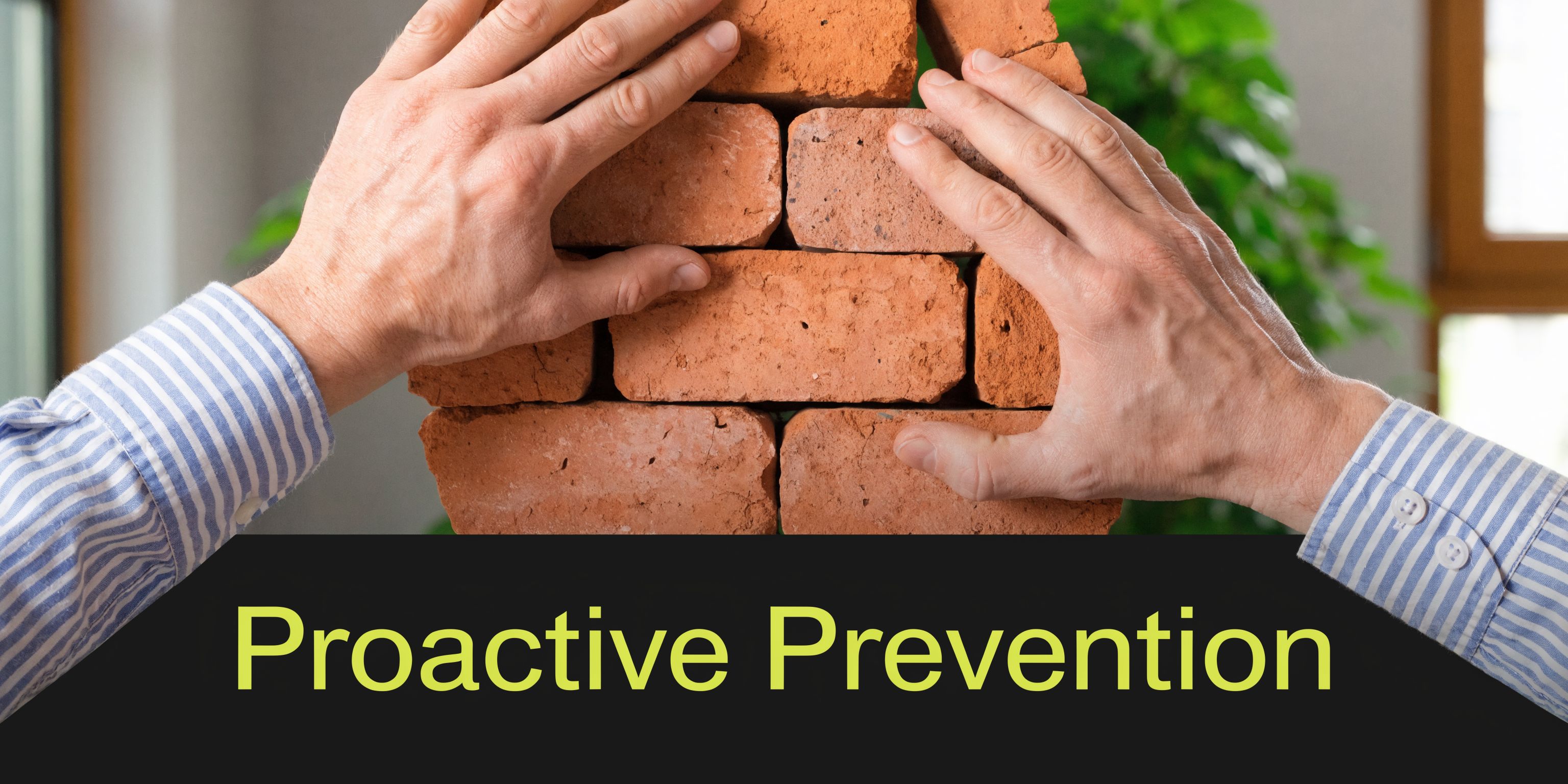 A pair of hands building a brick wall with the text Proactive Prevention overlaid at the bottom.
