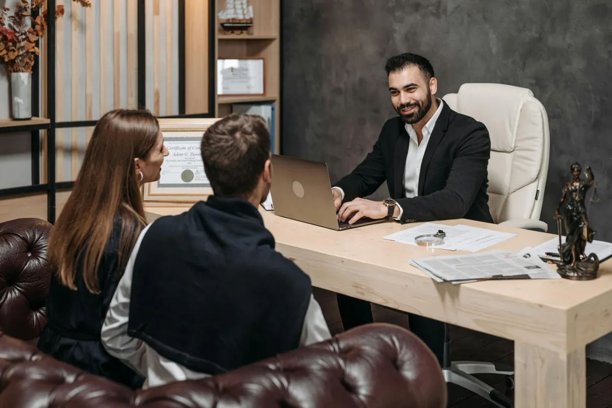 Financial advisor consulting with a couple in an office, discussing debt relief and wealth building strategies.