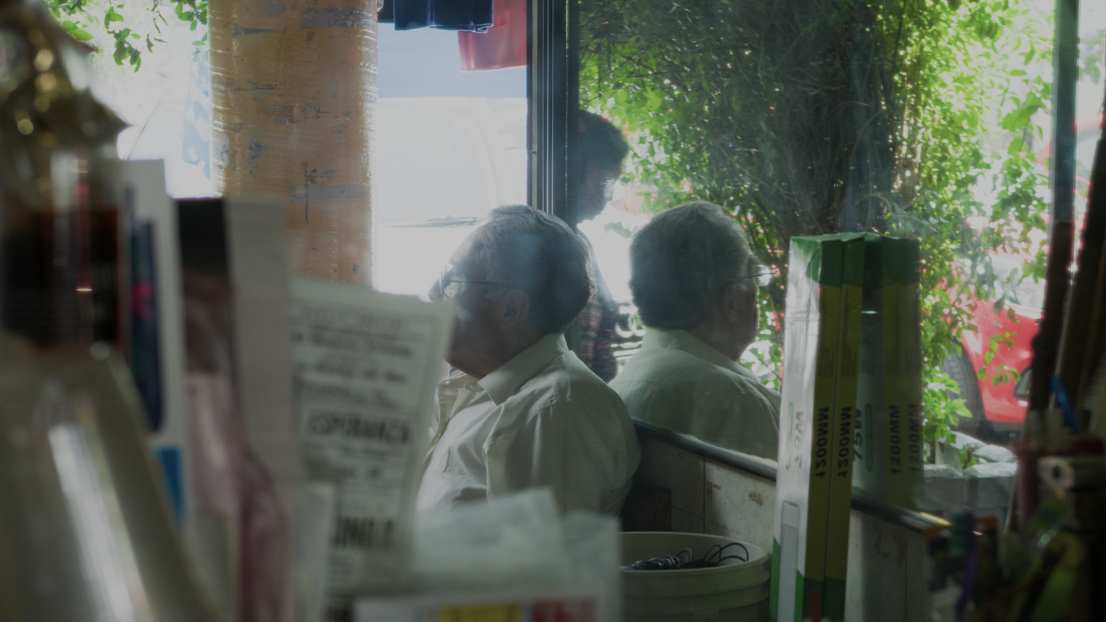 Cinematic still from the award-winning documentary 'Helado de Piñón', co-directed and photographed by Mexico City DP Mauricio Nader. The shot features a traditional barber in the iconic Mercado de Coyoacán, captured with a Blackmagic Pocket 6K G2 to highlight the authentic atmosphere of the location (Shorts Mexico Official Selection).