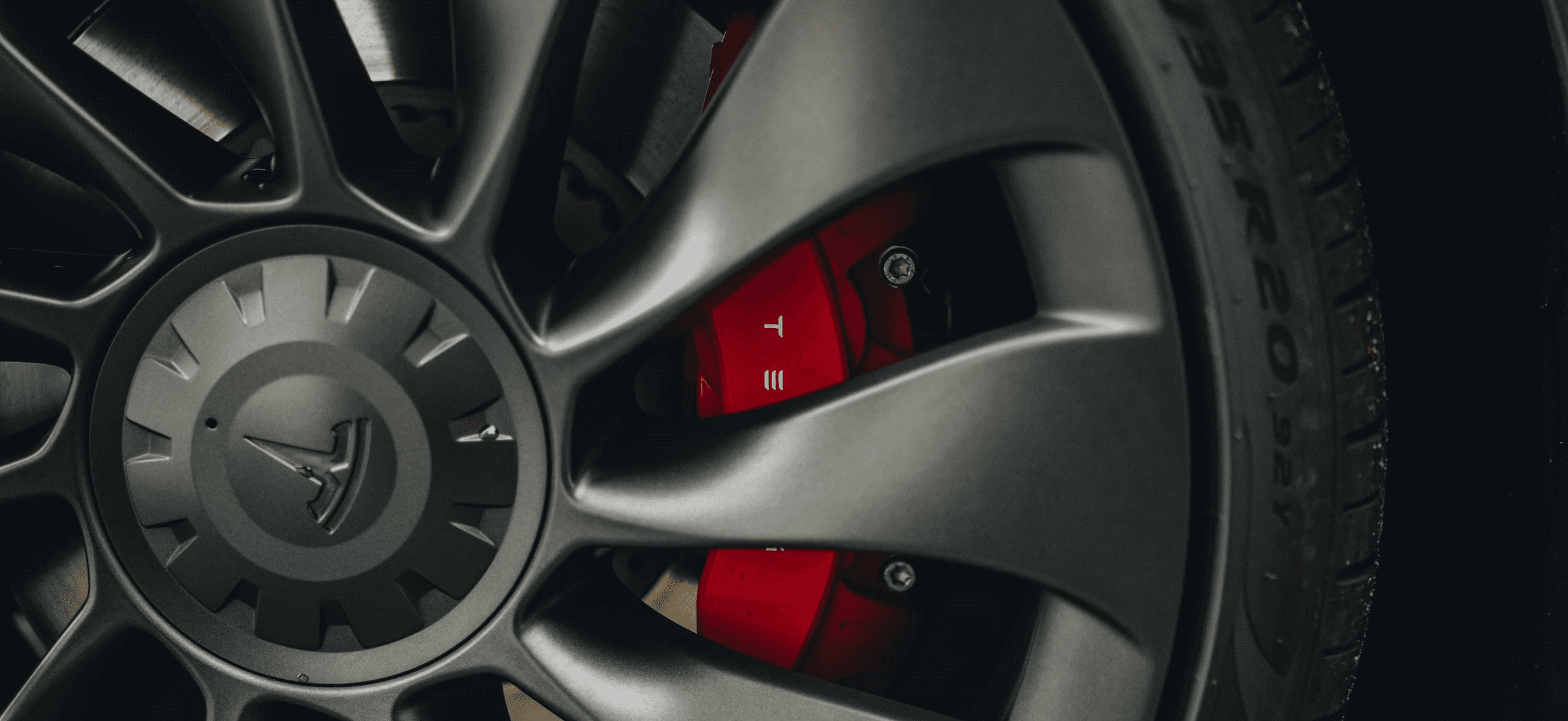 Roue de Tesla Model 3 Performance avec jante noire et étrier de frein rouge, détail sportif de la berline électrique