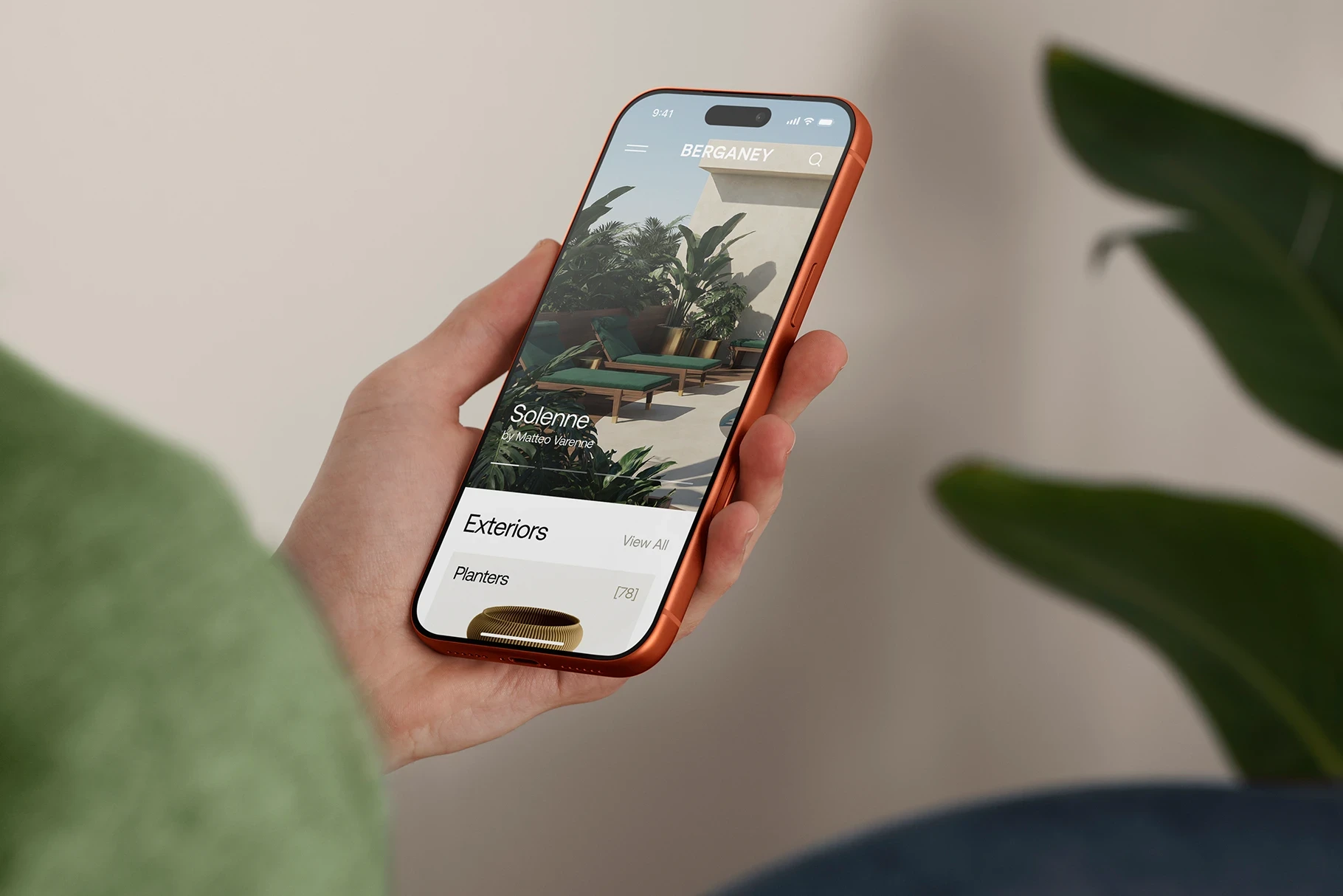 Person holding an iPhone 17 Pro in hand browsing outdoor furniture app.