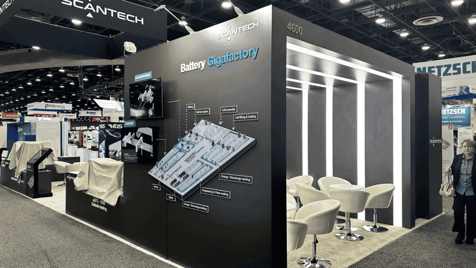 20x40 industrial product booth with equipment graphics, demo area, lighting frame, and meeting seating for construction exhibitors