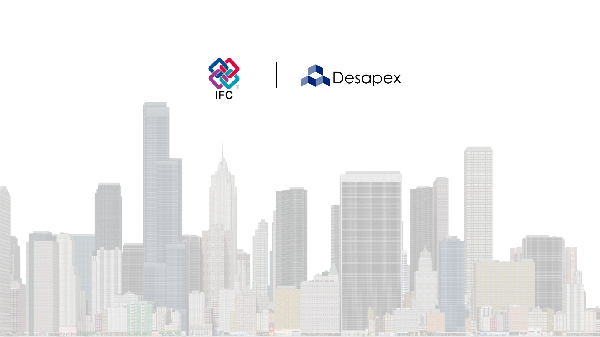 A man stands while two people sit at a table in an office setting, smiling and engaged in conversation. The mood is friendly and collaborative.