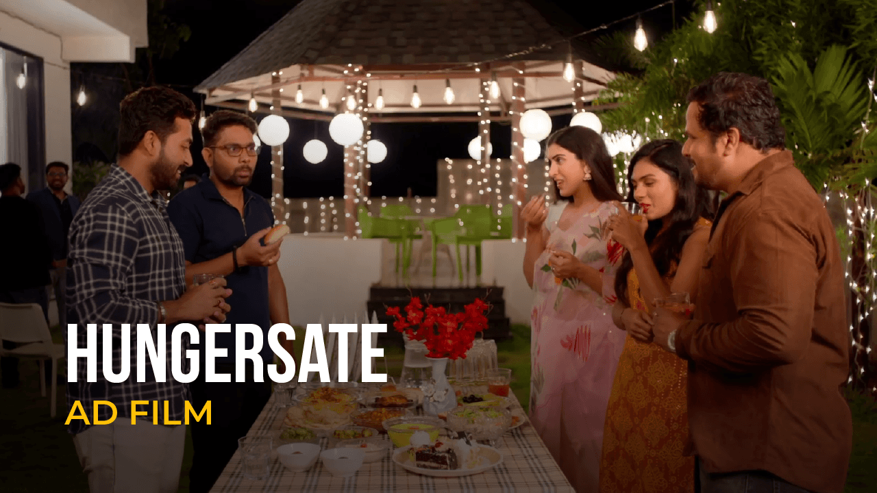 Group of friends gathered around a dinner table in a Hungersate ad film.