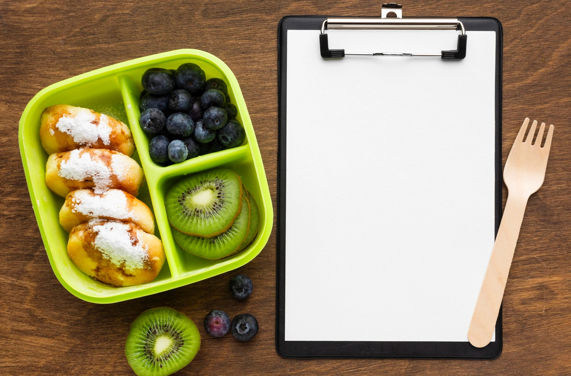 Healthy foods arranged next to a clipboard and fork, emphasizing professional nutrition tracking with the Caloric app