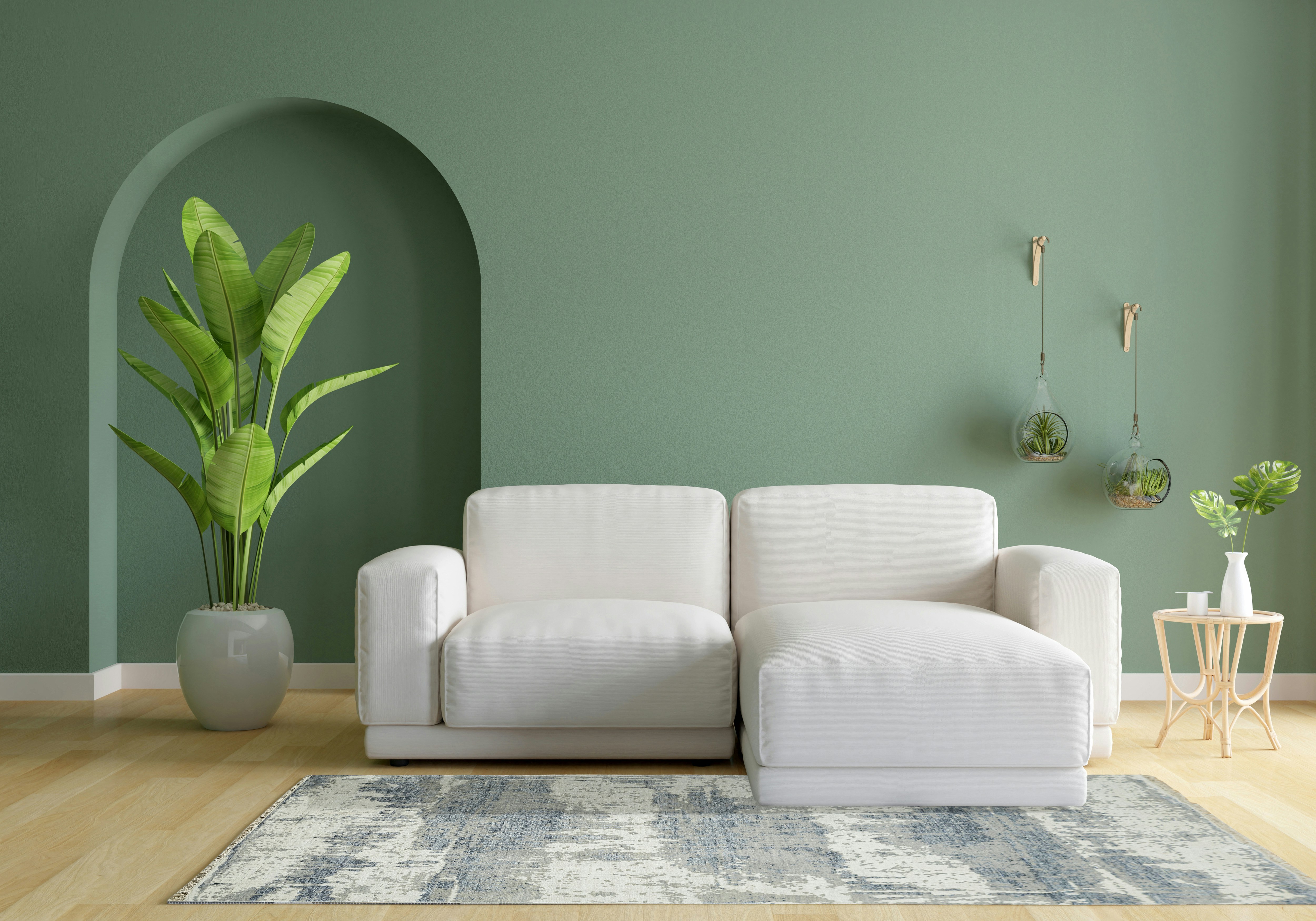 A living room with green walls and a white couch