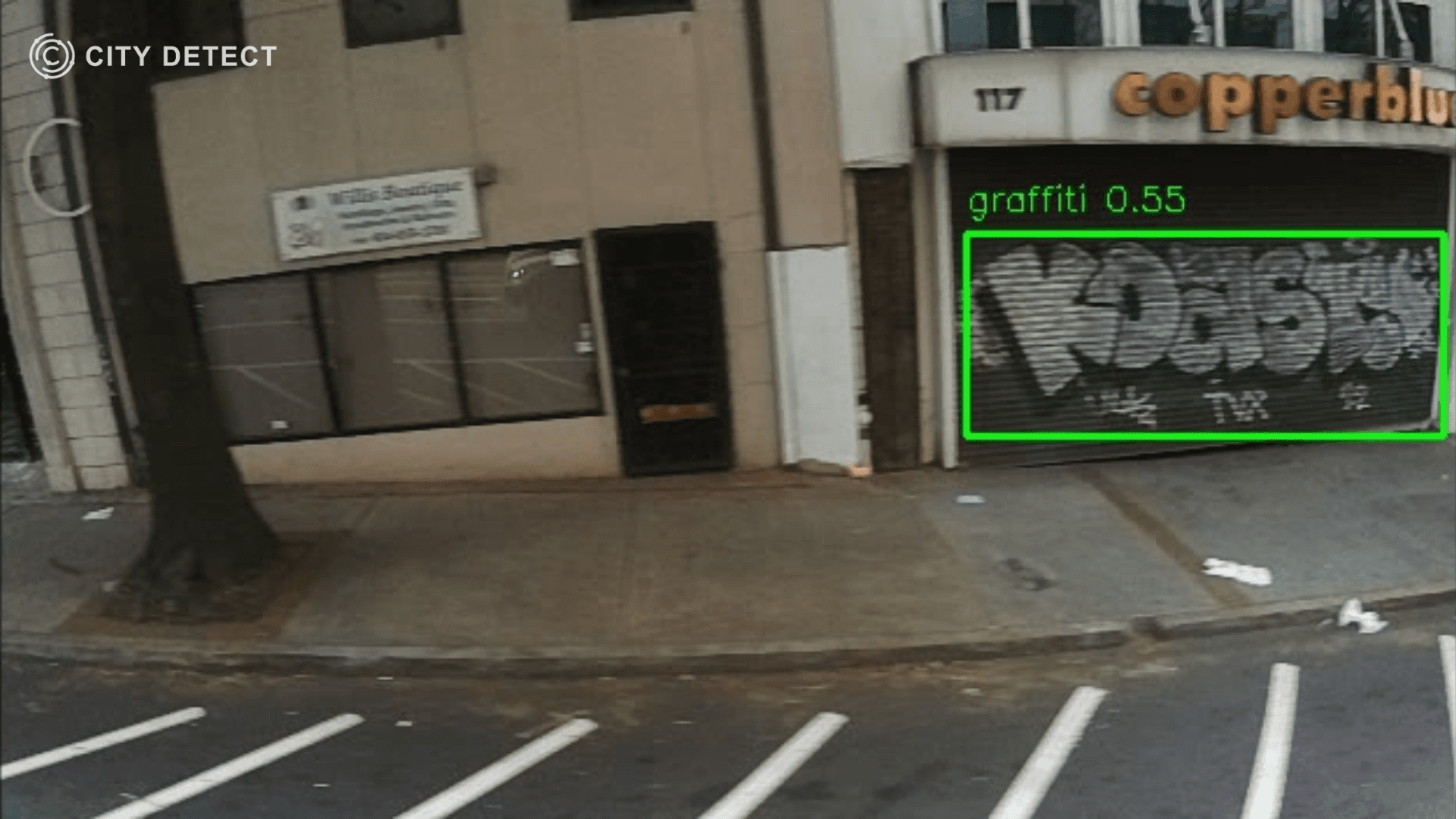 Street scene with building tagged with graffiti, and text in a box "graffiti 0.55" detected.