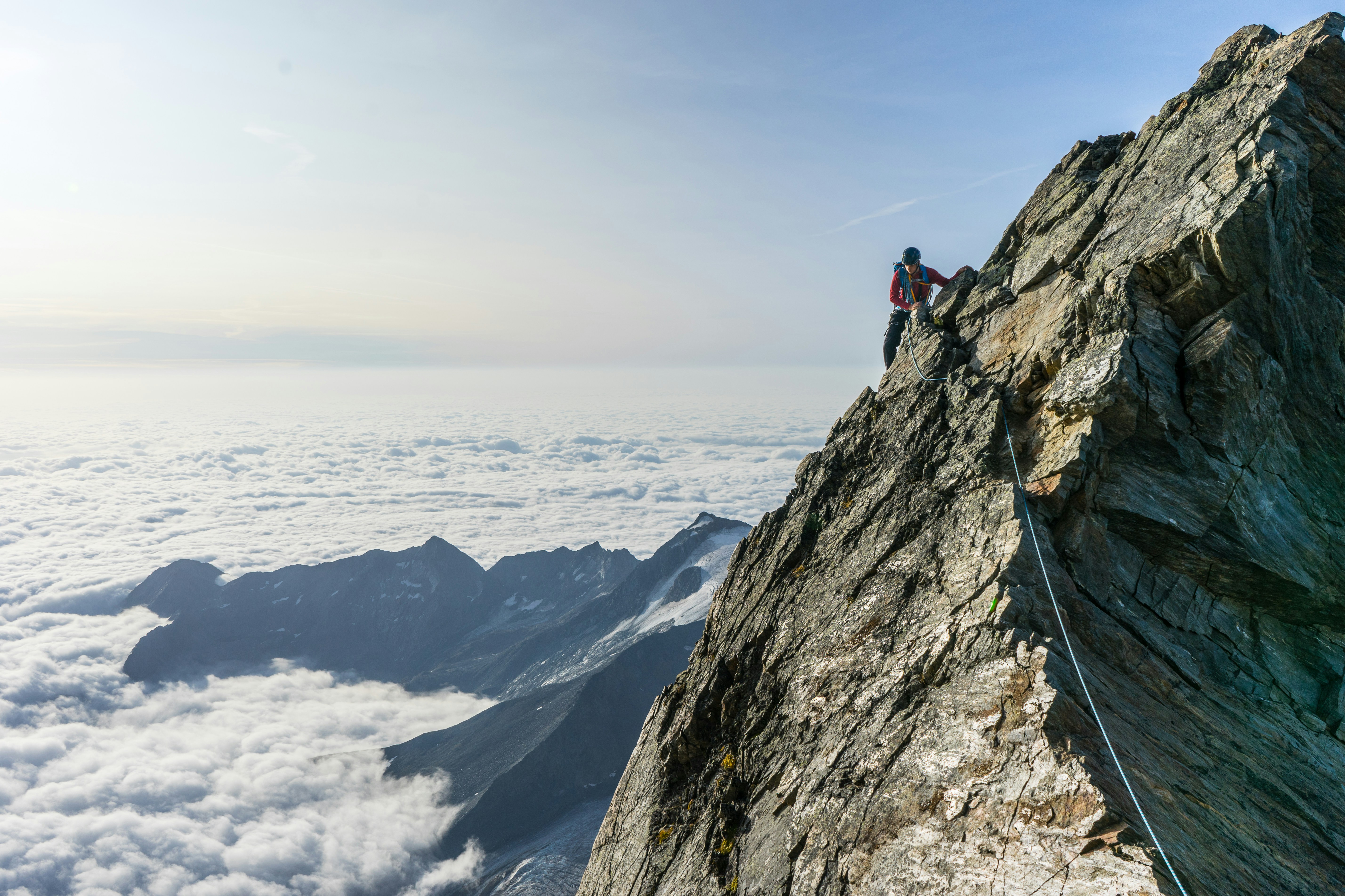man climbing on gray mountain