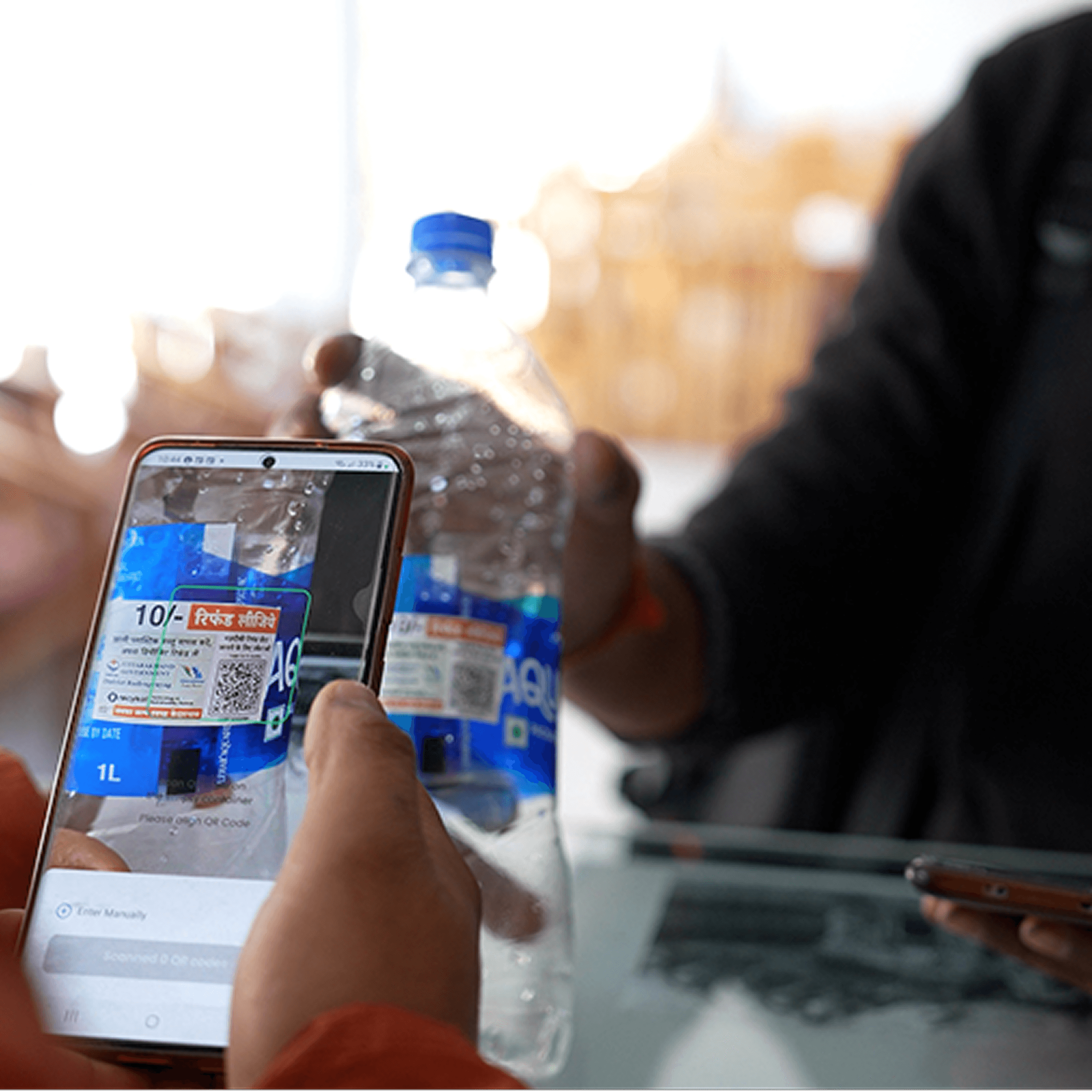 Woman in red outfit poses by a red telephone booth.