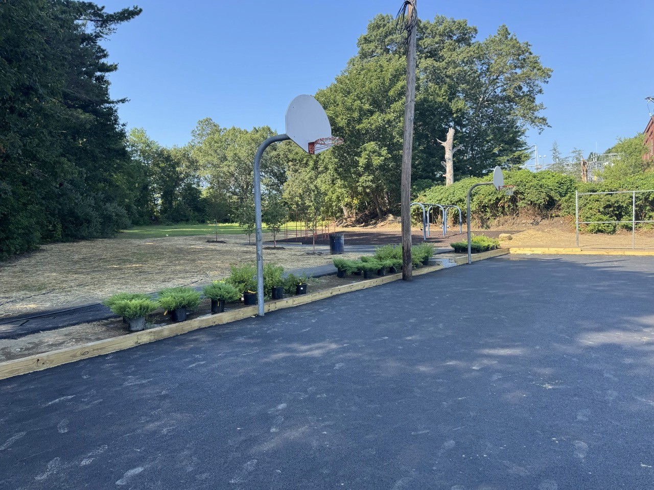 After: Repaved basketball court under summer sky