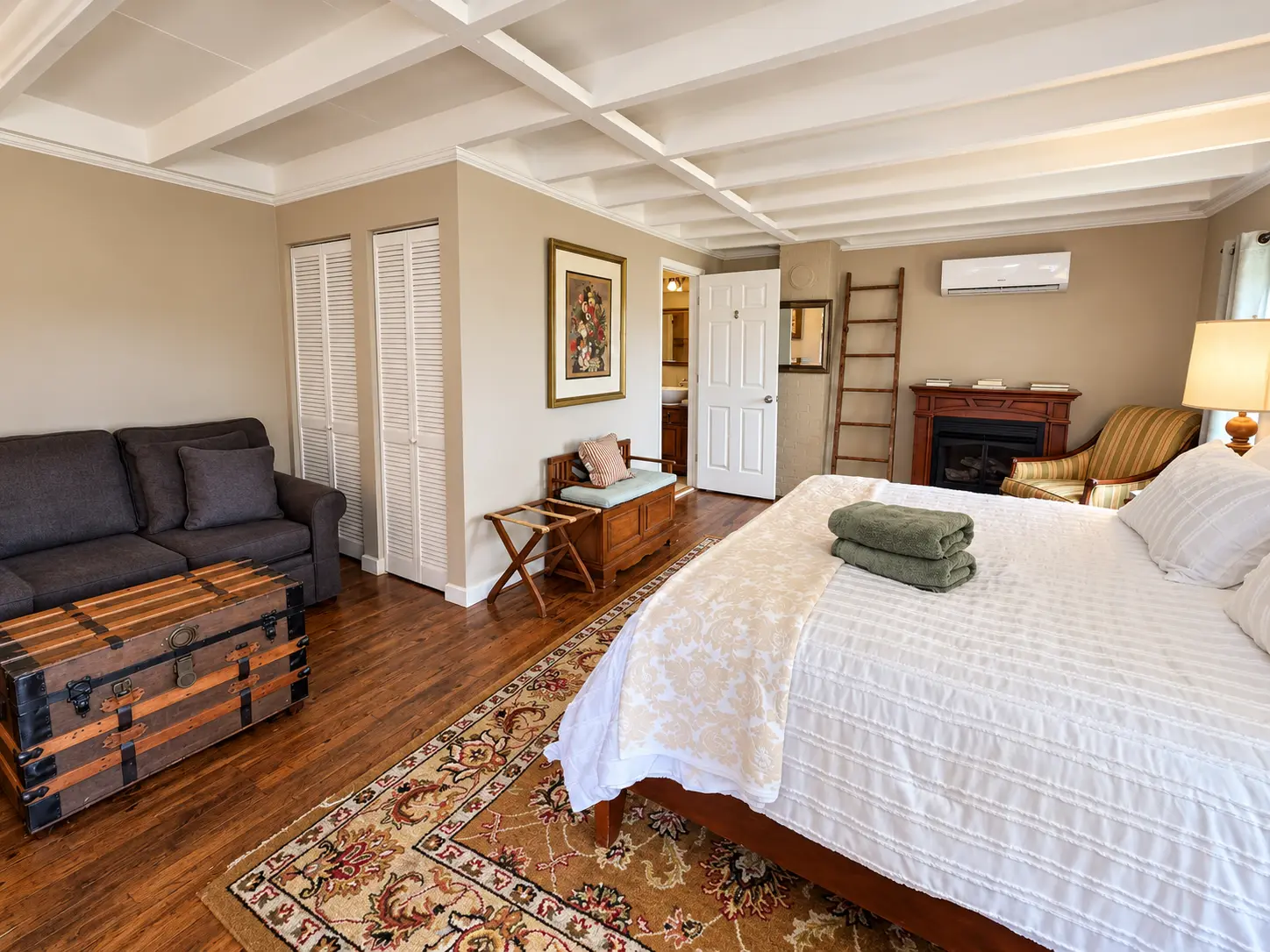 Bedroom with large bed, red sofa, and open door to patio.