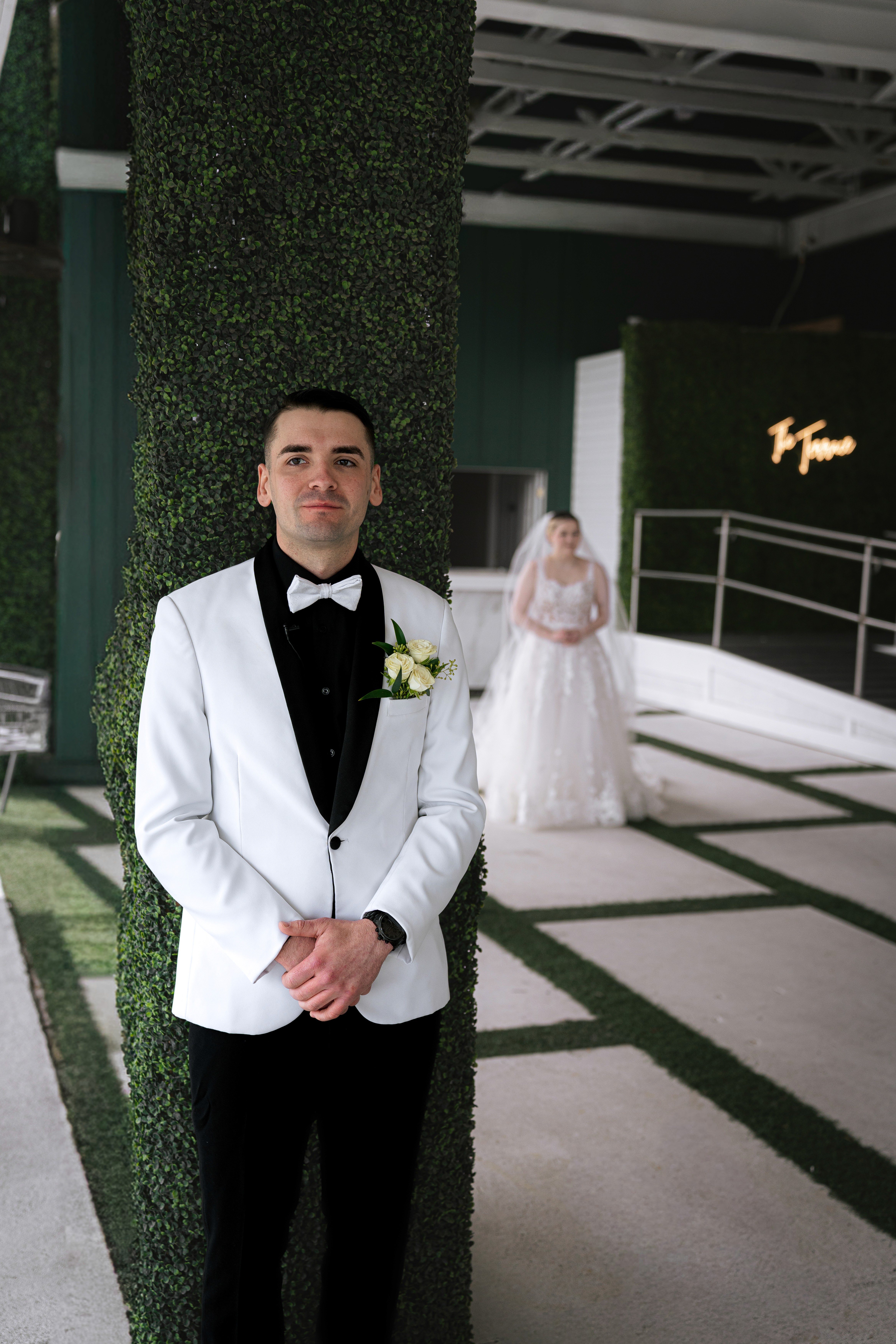 A couple embraces lovingly on a rustic wooden bridge.