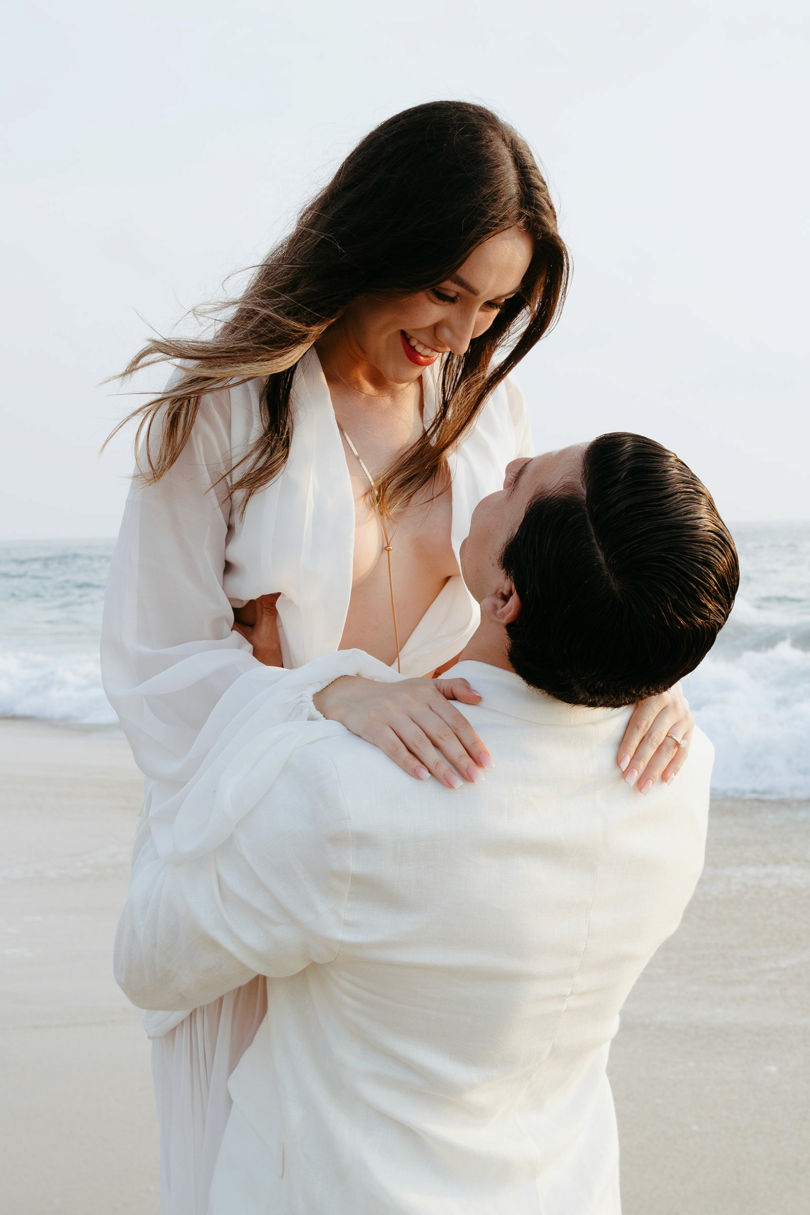Momento de compromiso capturado durante una sesión fotográfica en la playa