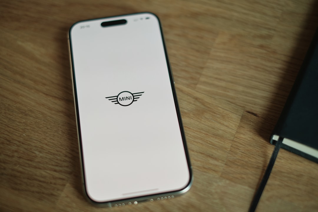 A white cell phone sitting on top of a wooden table