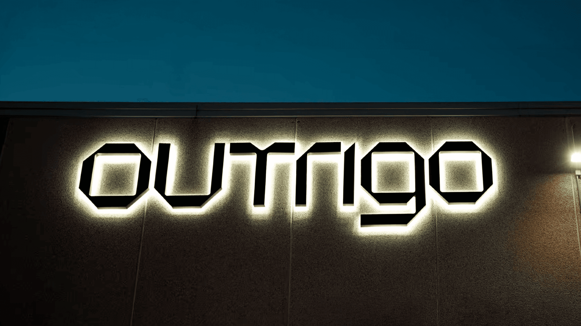 Four diverse professionals collaboratively working on a laptop, with one person pointing at the screen while others observe.