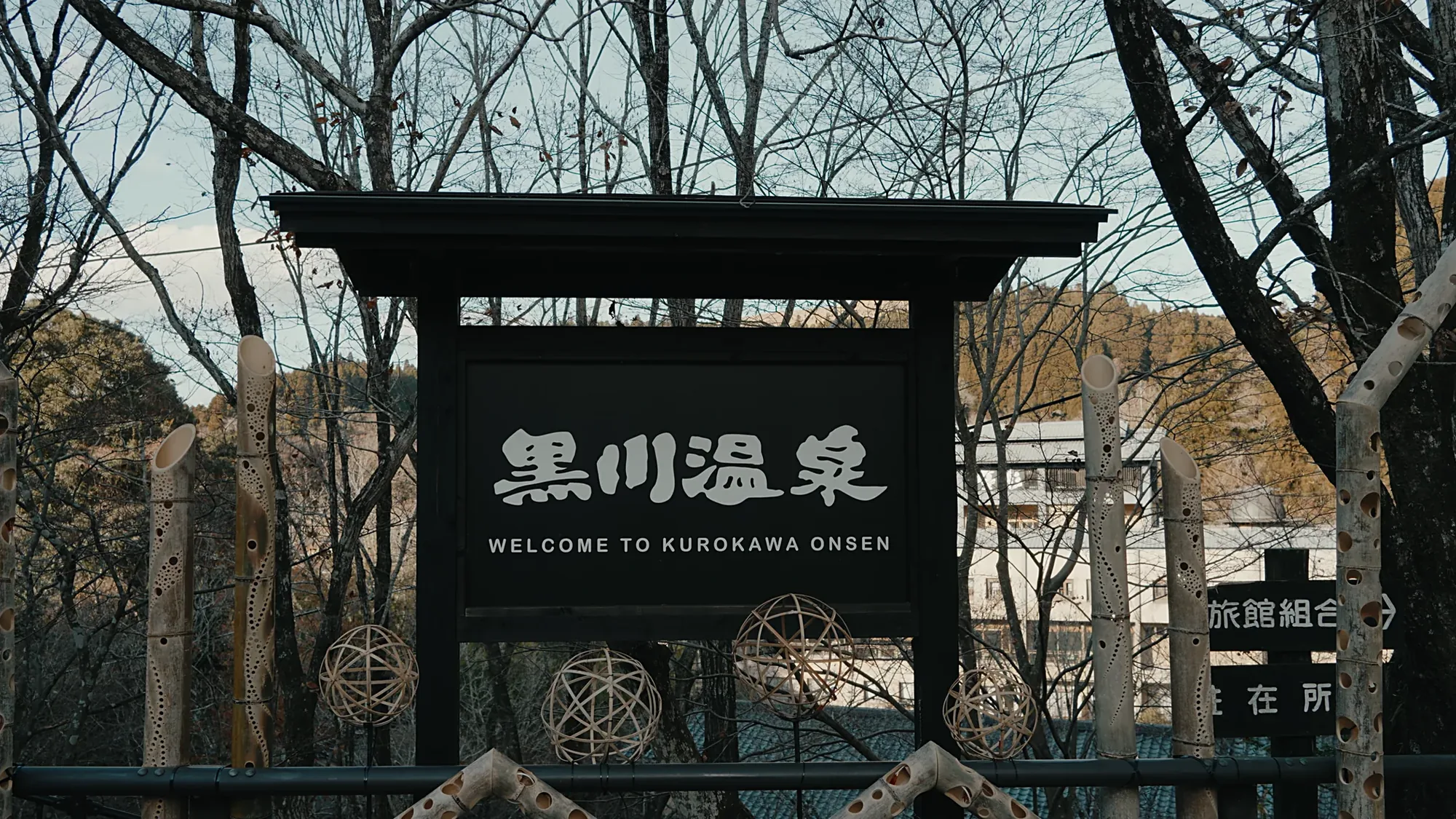 The timber welcome board at Kurokawa Onsen, the ryokan association's information office signed behind it