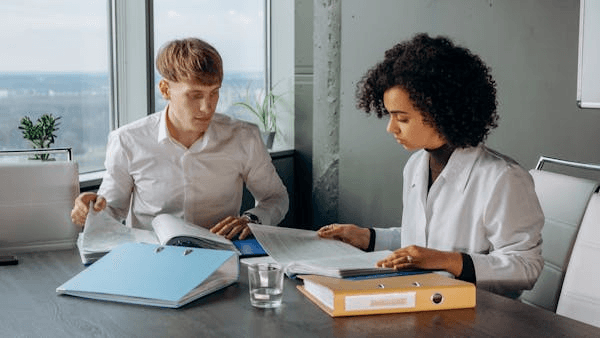 Two professionals reviewing documents in an office