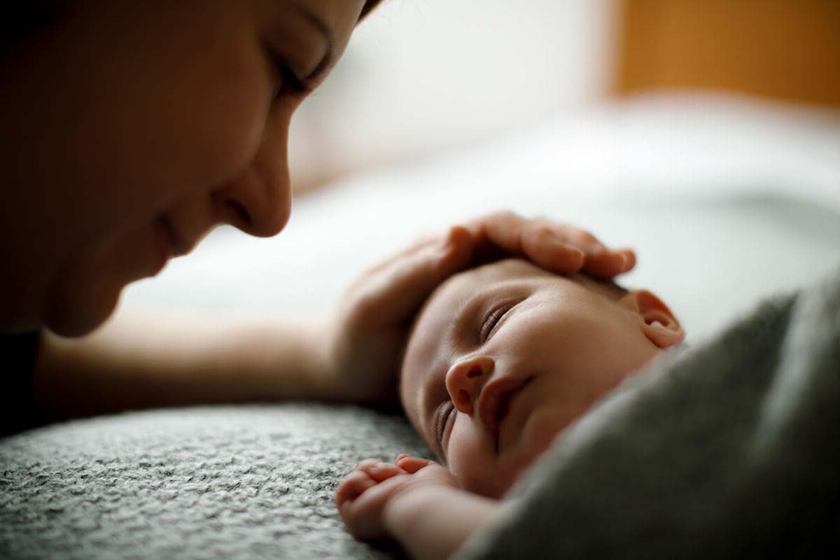 mother with her hand on baby's head