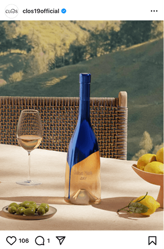 Lifestyle shot of blue rosé wine bottles on set table against Mediterranean background with mountains. Instagram post.