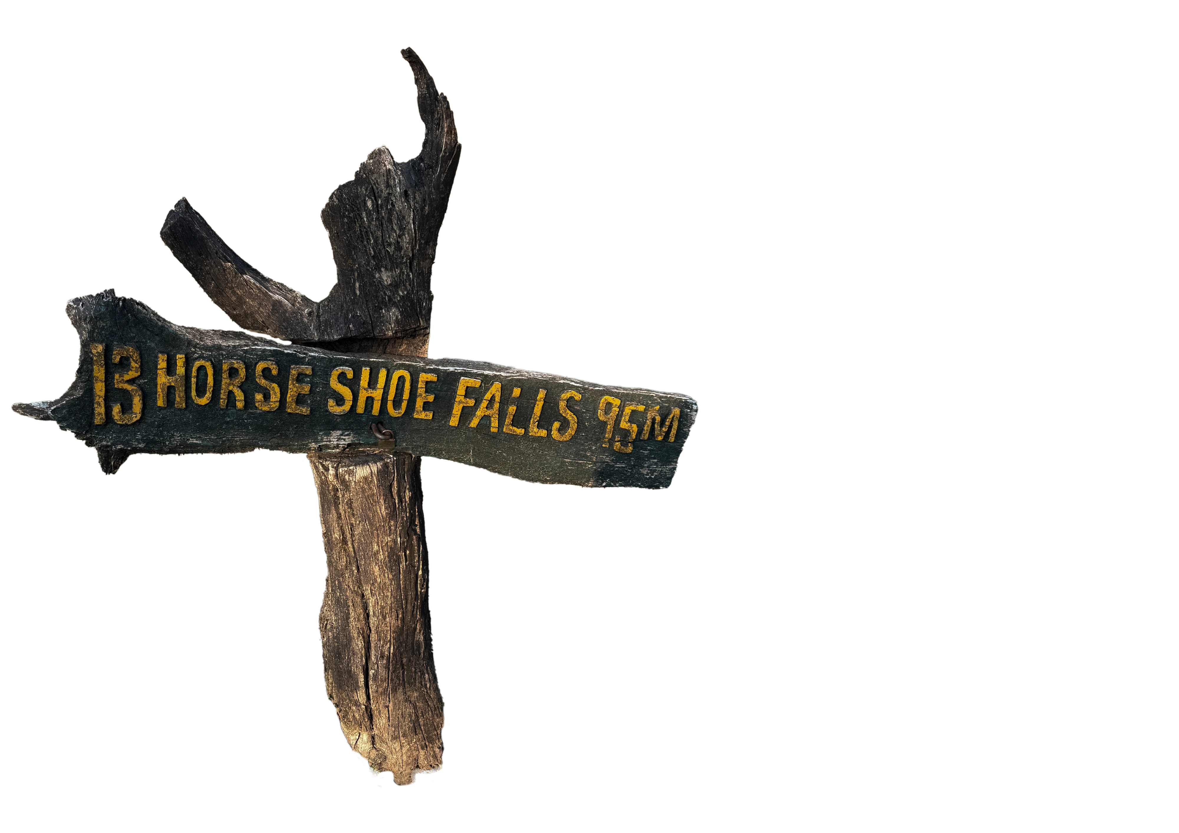 Weathered dark wood signpost made from branches, carrying yellow hand-painted lettering.