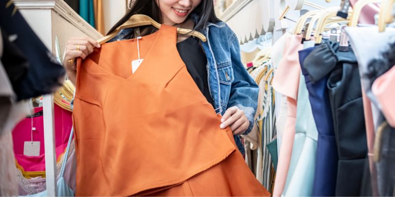 Seorang pembeli runcit di Malaysia sedang mencuba pakaian