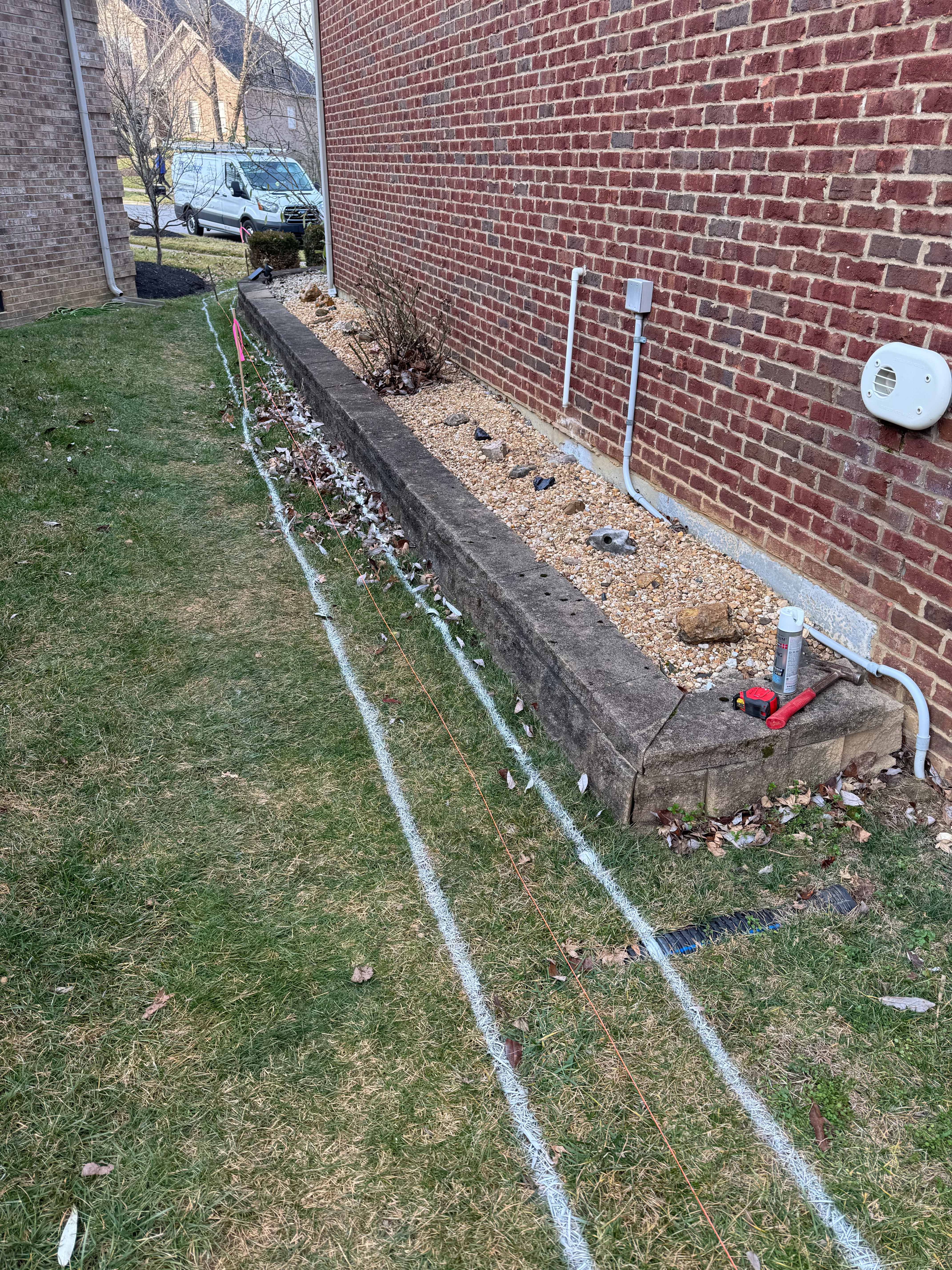 Marked lawn and garden bed with utility spray paint before excavation
