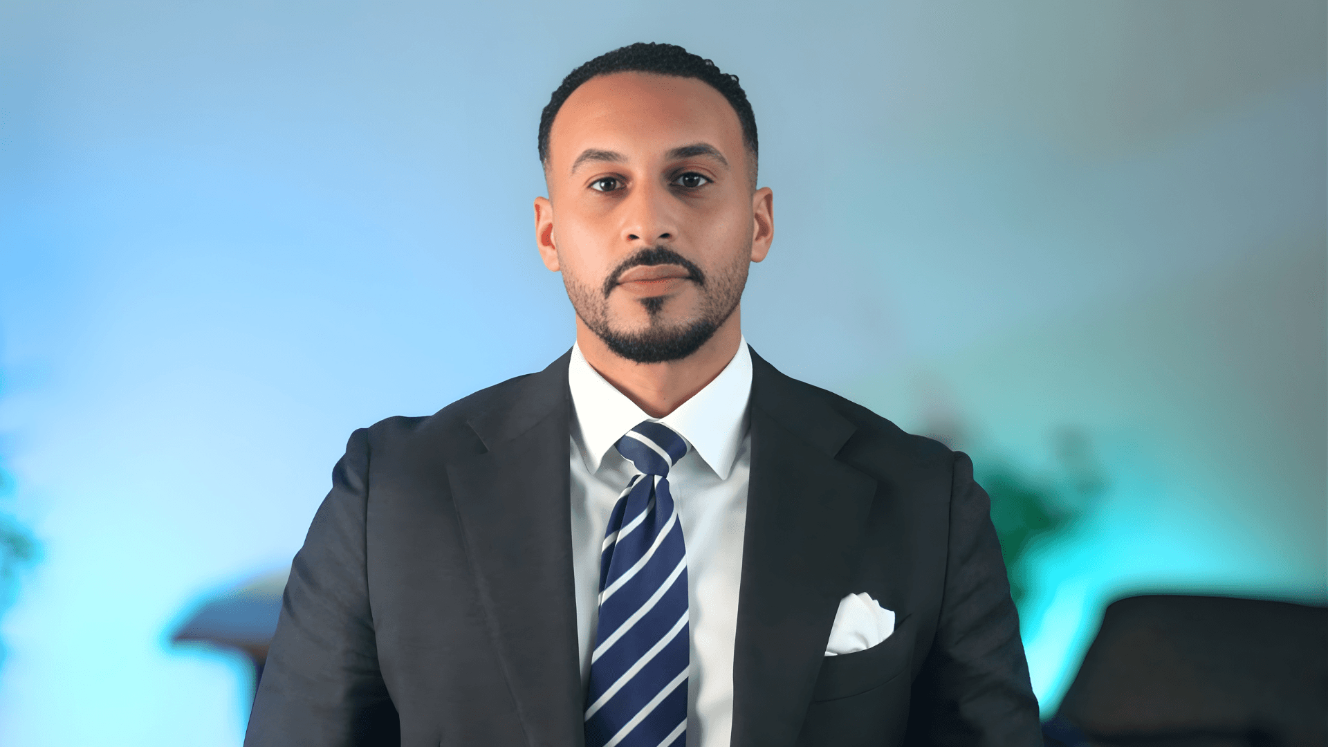 A woman with short curly hair wearing a black t-shirt looks into the camera.