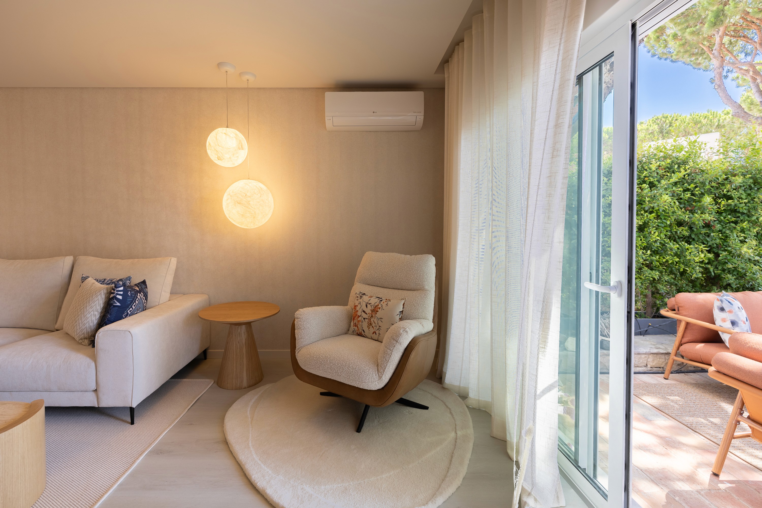 Living room in warm evening light, opening onto the terrace